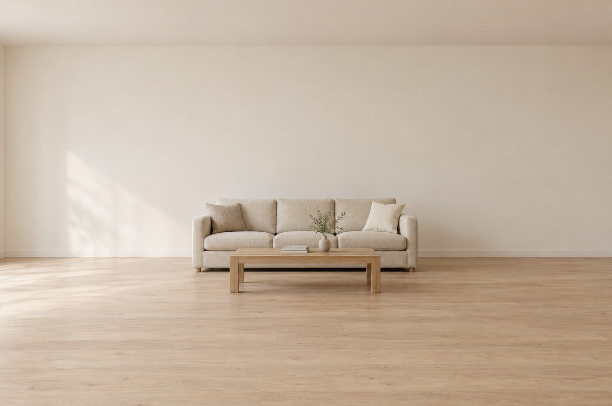 Empty styled living room with a neutral three-seat sofa and a low light oak rectangular coffee table set a short distance in front of it, warm natural daylight, pale oak floor