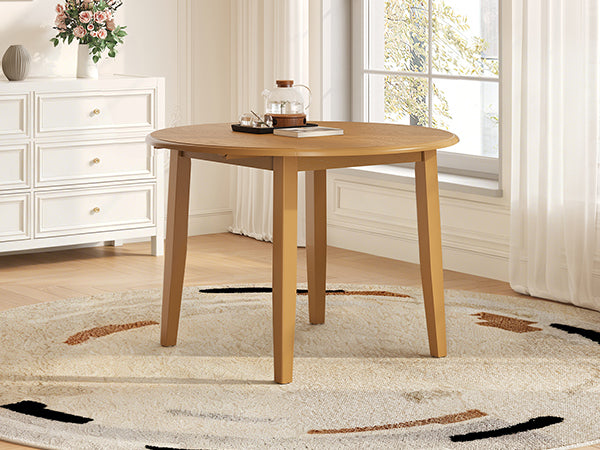 Styled room with the full round light brown table beside a bright window
