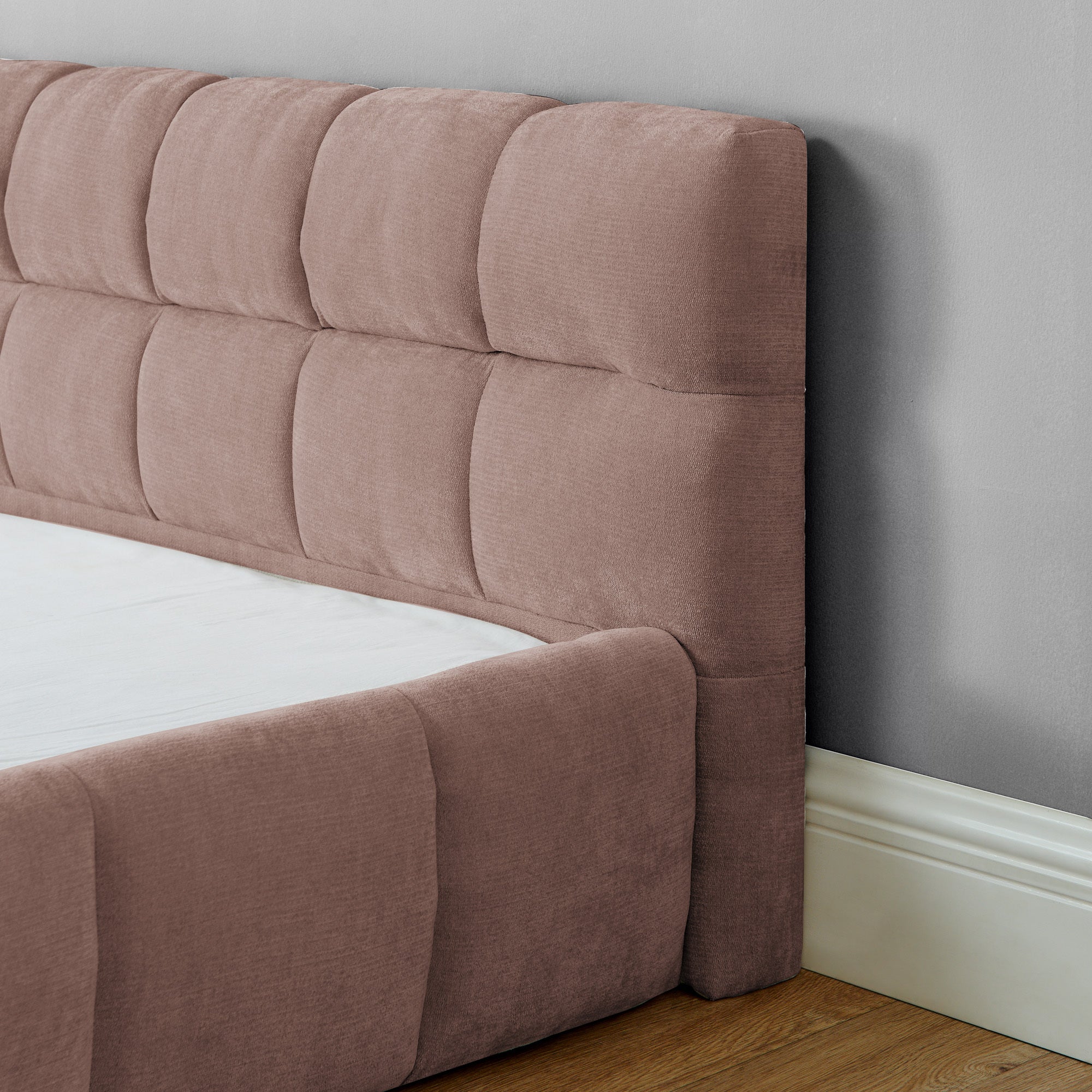 Close-up of channel-tufted pink chenille headboard corner detail