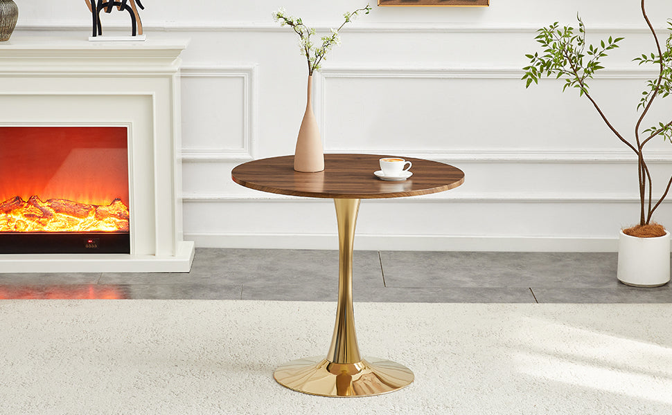 Walnut round dining table with gold pedestal by a fireplace and potted plant, front view