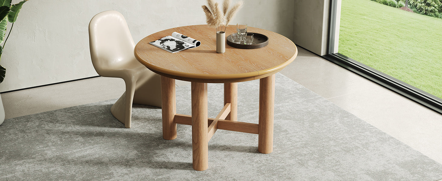 Extended oval oak table with two cream chairs beside a large garden window