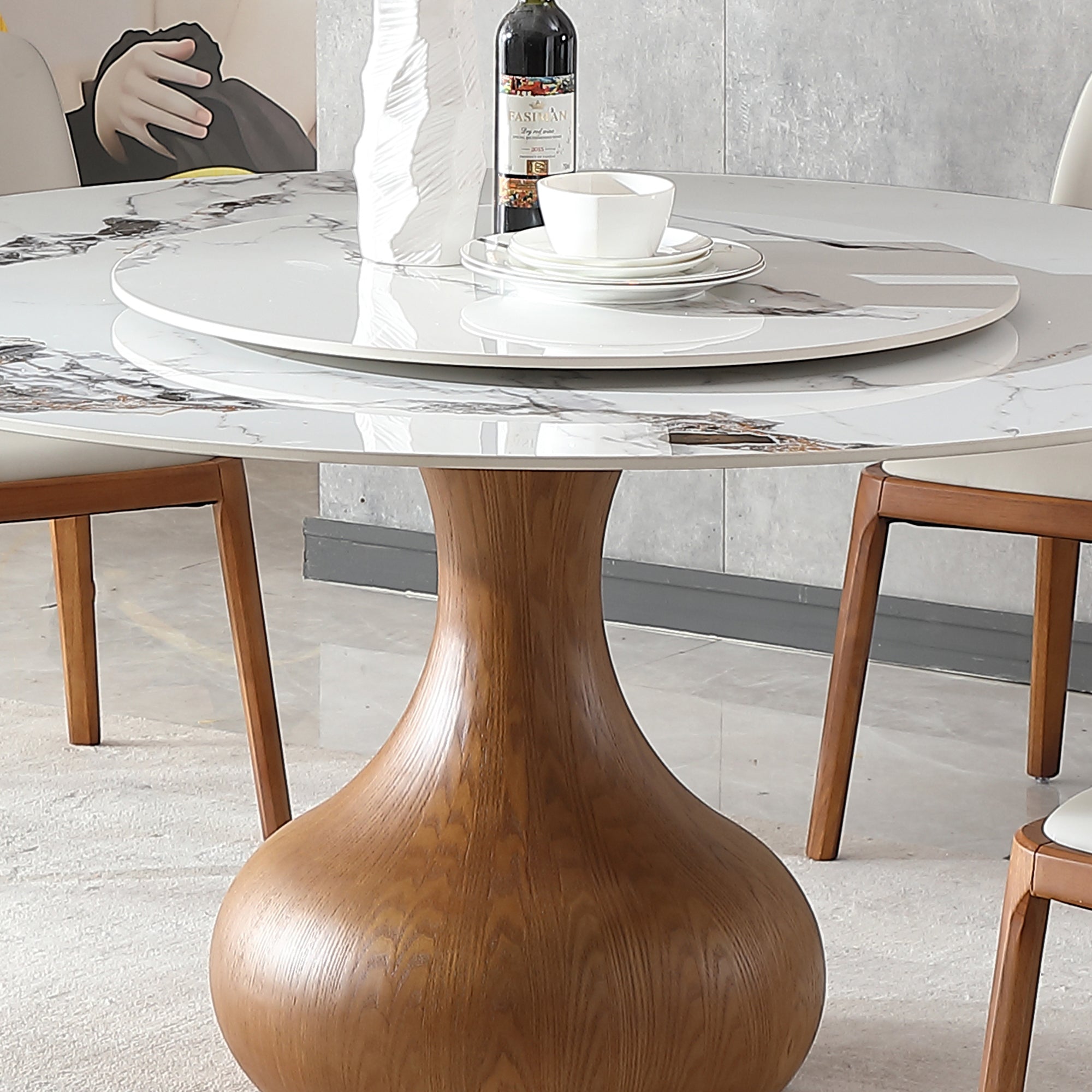 Close-up of the sintered stone top, center turntable and wood urn pedestal with a cup and wine