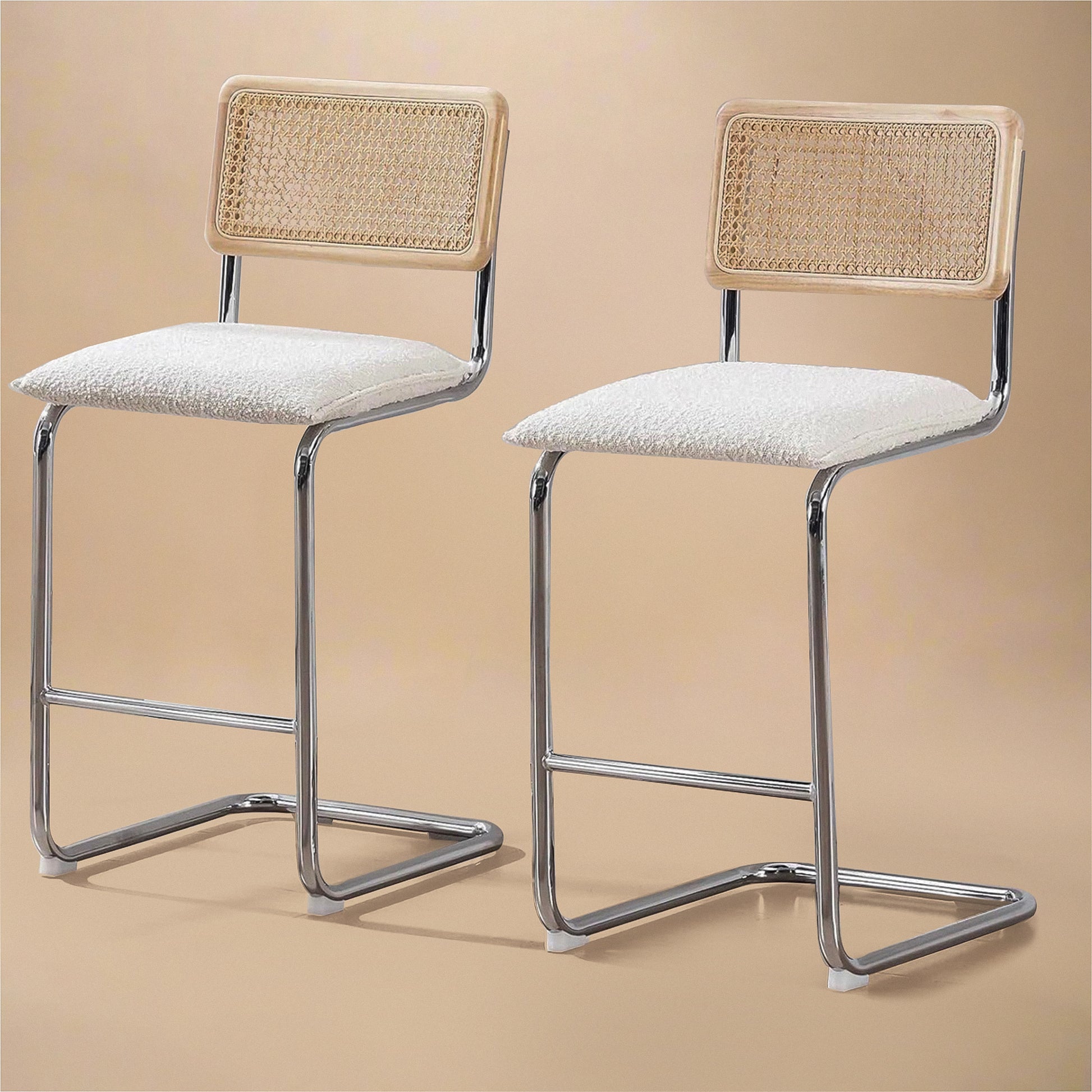 Midcentury Modern Counter Stools Set of 2 with white bouclé seats, rattan backs, and stainless steel legs.