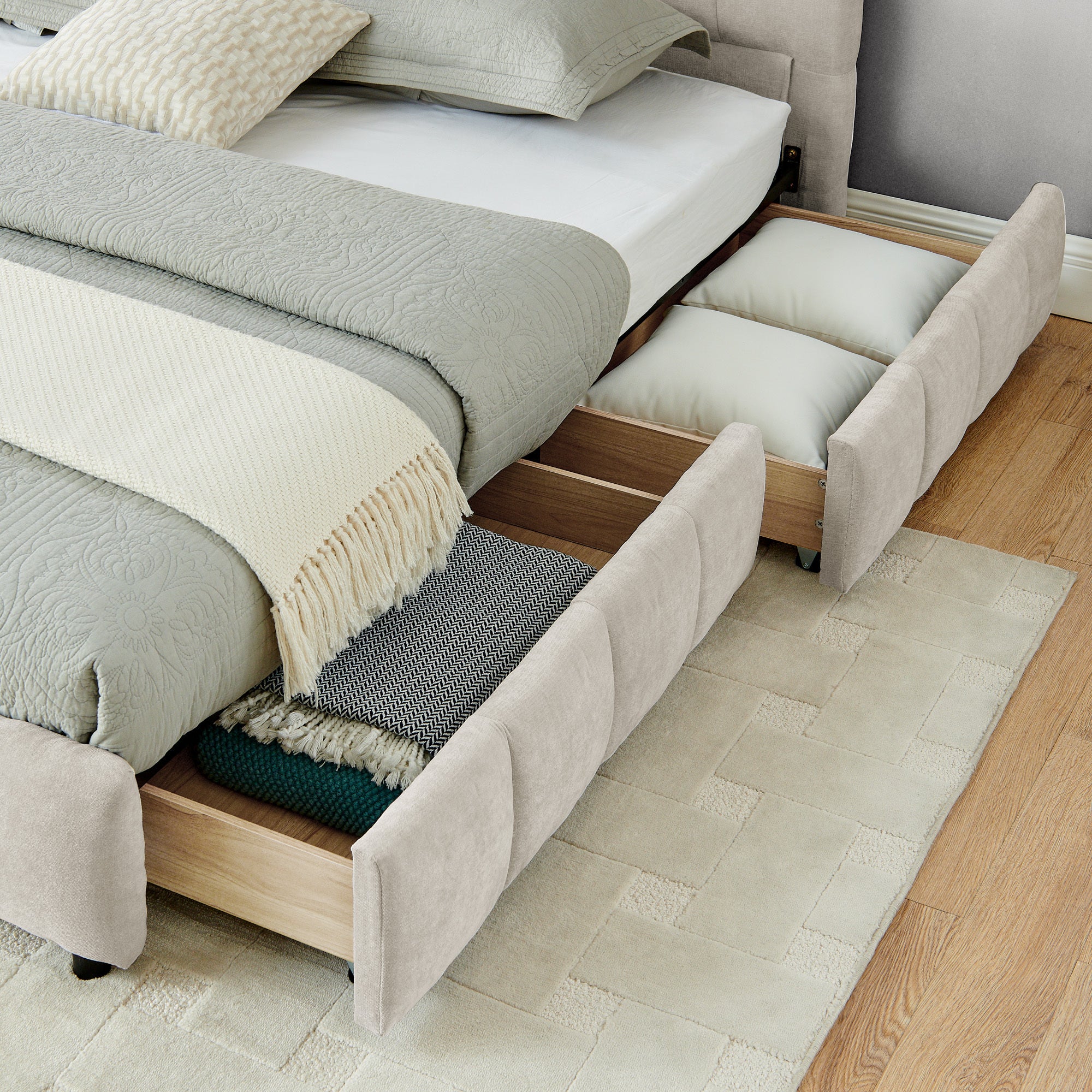 Close-up of open underbed drawer with throw and pillow inside