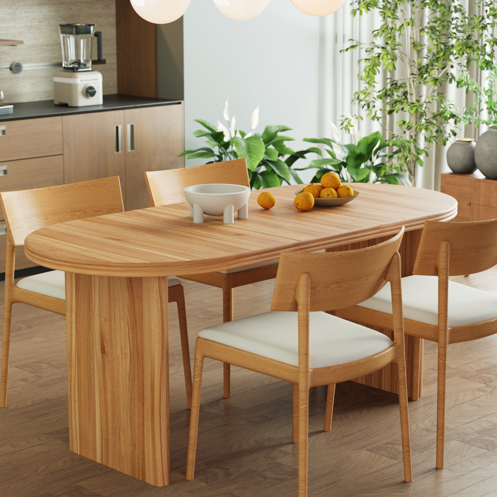 Overhead view of the extended oval table with a bowl of oranges and plants nearby