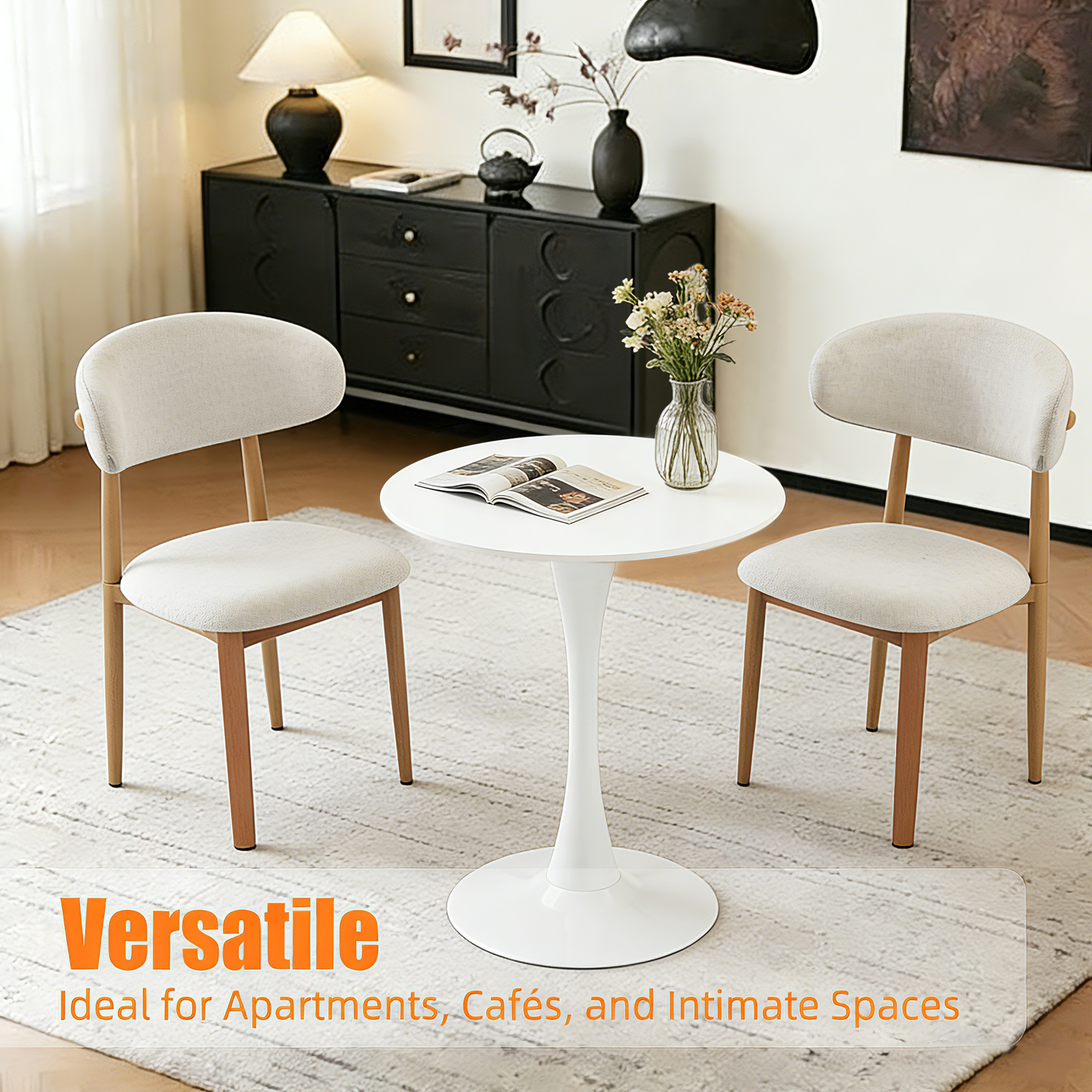White round tulip bistro table in a styled room with two cream chairs and a flower vase