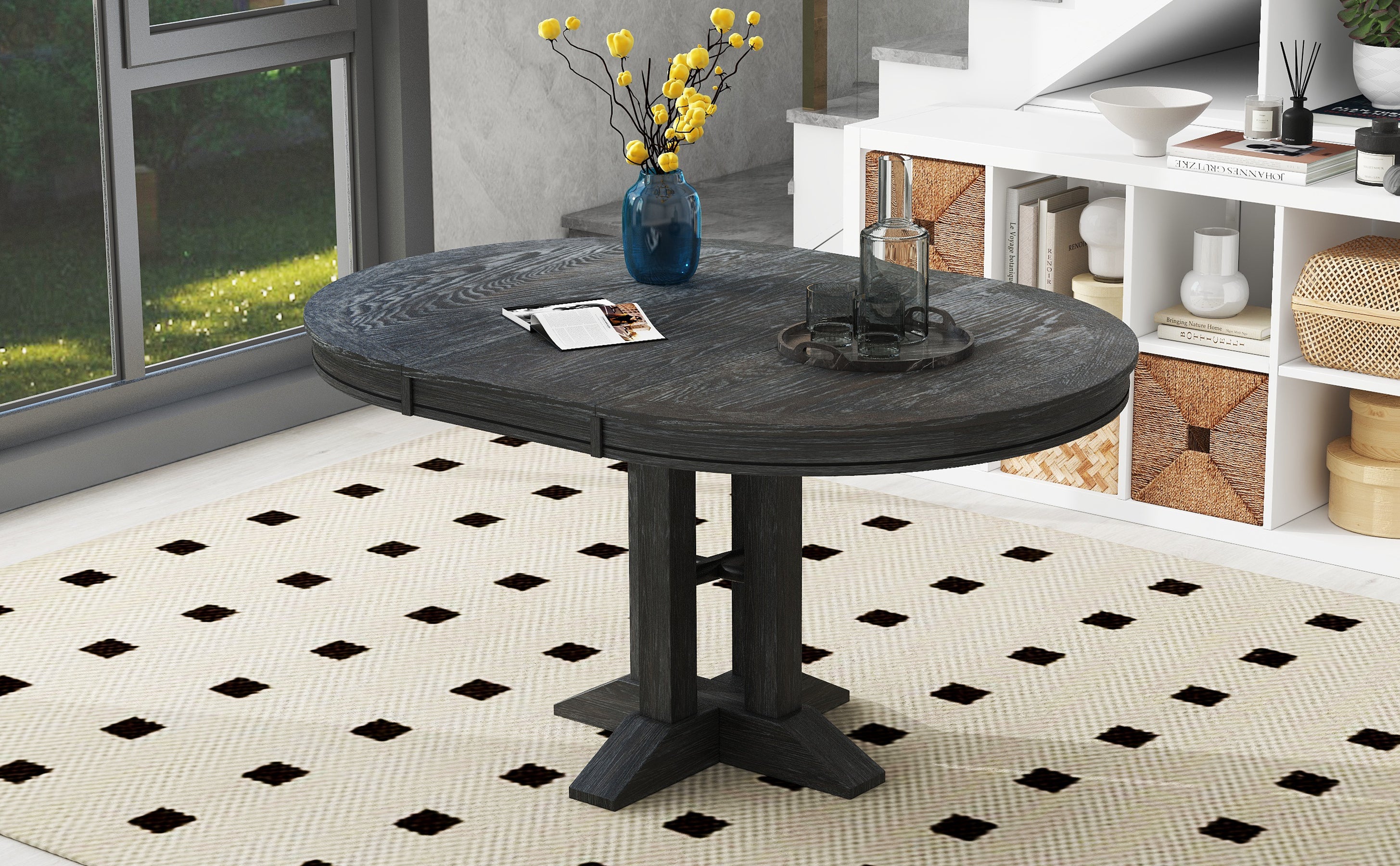 Black oval-extended dining table styled near a staircase and shelving
