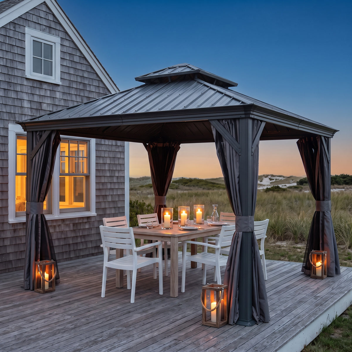 Gray 10x12 hardtop gazebo with tied back curtains over a dining table on a deck by the dunes at dusk