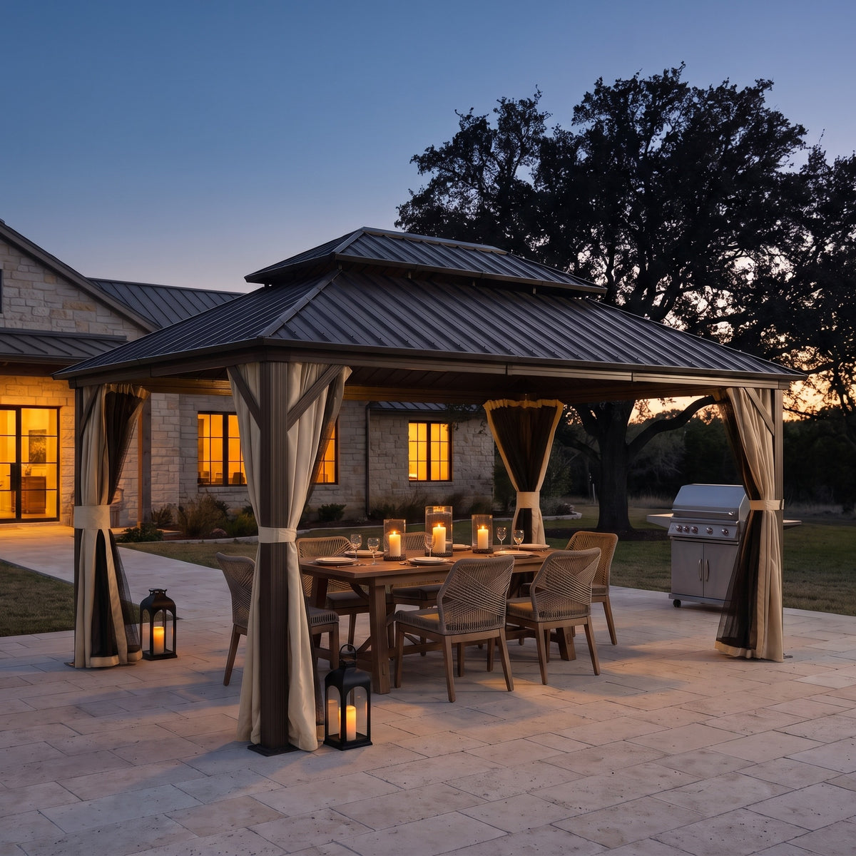 Brown aluminum 10x14 double roof hardtop gazebo with tied back curtains over a candlelit dining table on a patio at dusk
