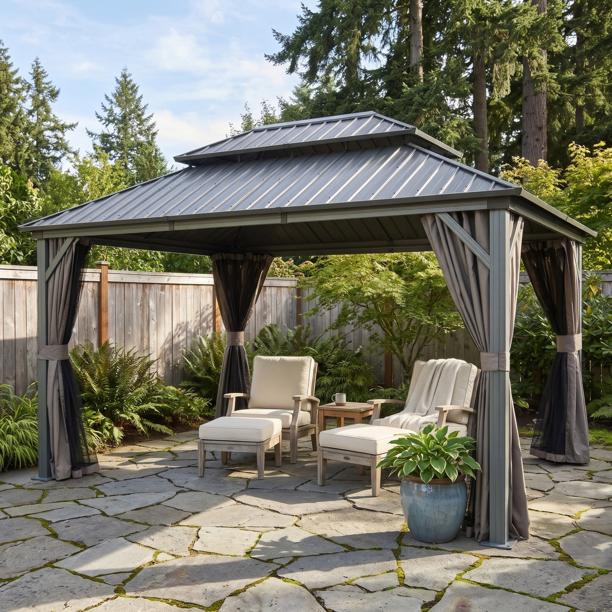 Gray aluminum 10x14 double roof hardtop gazebo with tied curtains over lounge chairs on a flagstone patio
