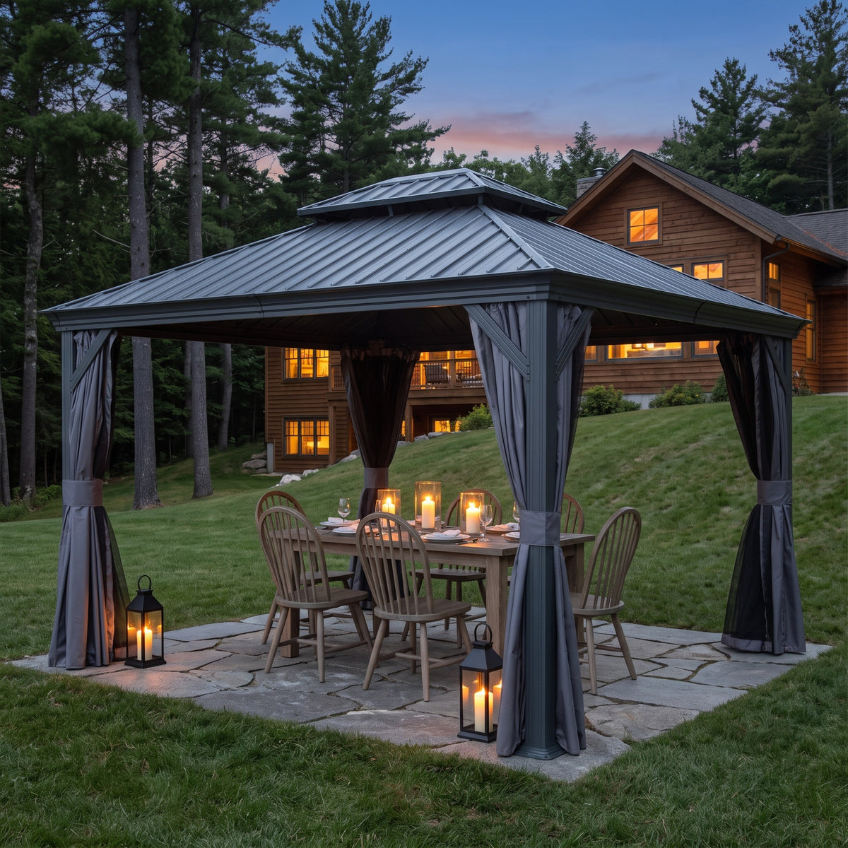 Gray steel double roof hardtop gazebo with tied curtains over a candlelit dining table on a stone patio at dusk