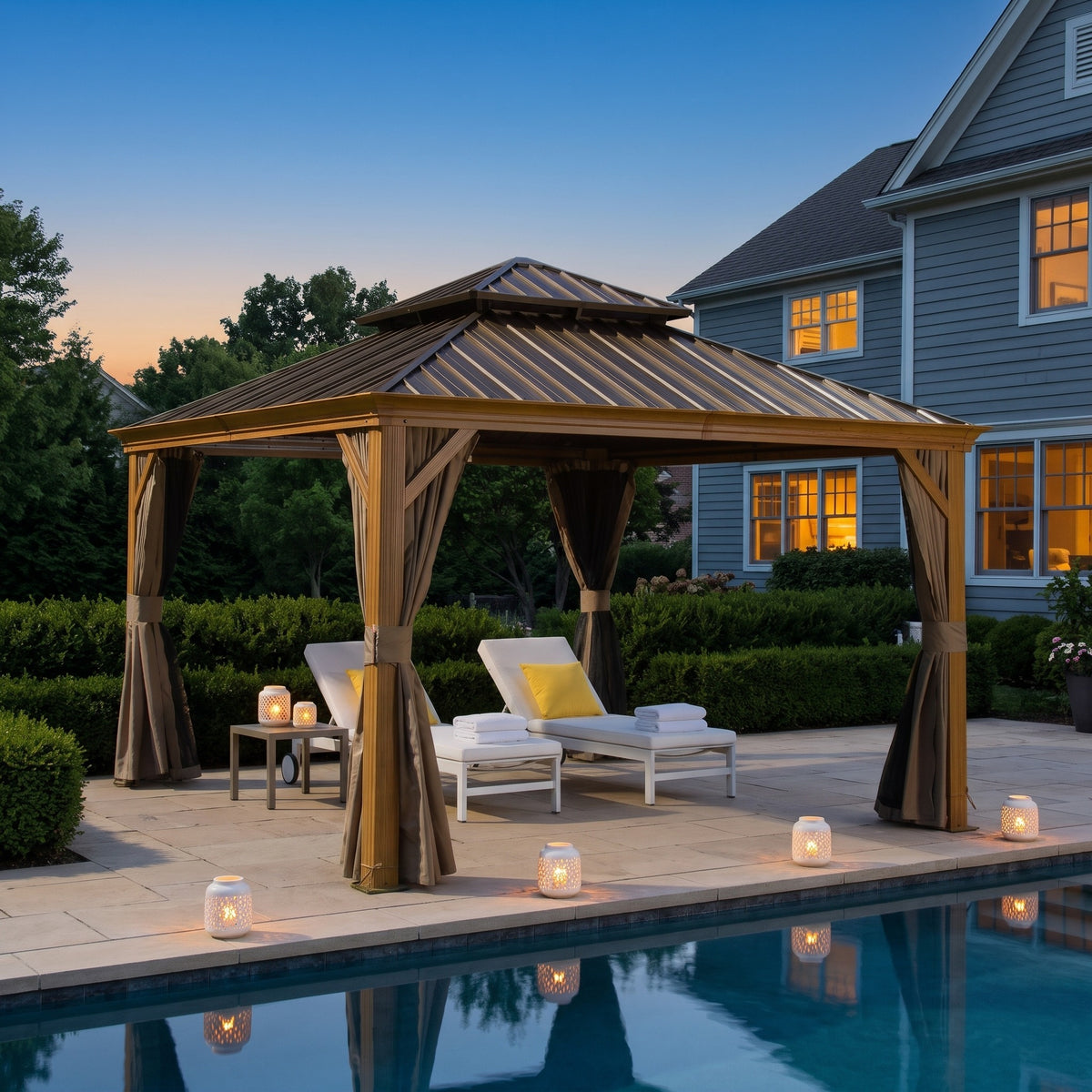 Yellow brown aluminum 12x12 double roof hardtop gazebo with tan curtains over two loungers by a pool at dusk