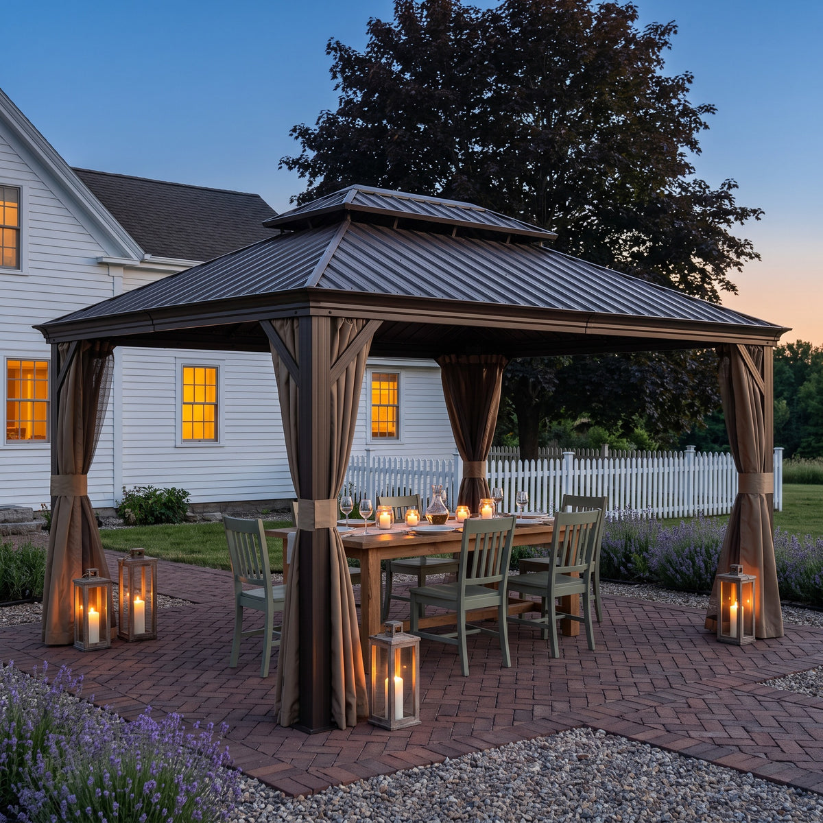 Brown aluminum 12x16 hardtop gazebo with tied back curtains over a dining table on a brick patio at dusk
