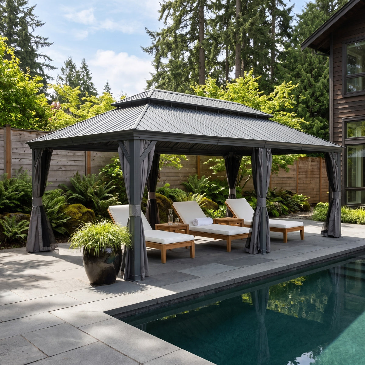 Gray aluminum 14x22 double roof hardtop gazebo with tied back curtains over three loungers beside a pool