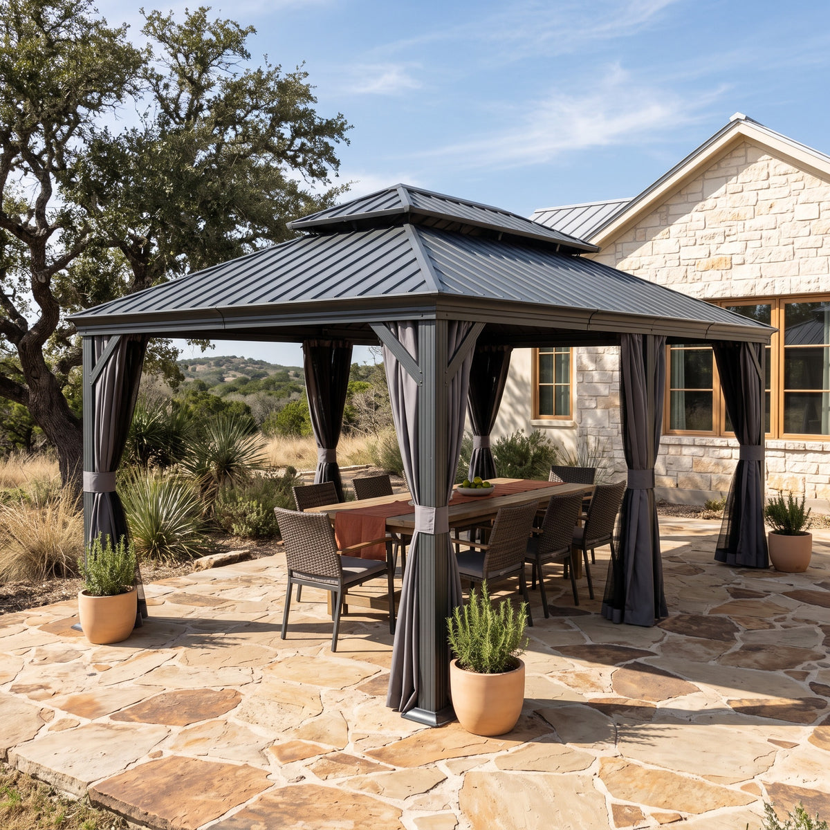 Dark gray 14x24 hardtop gazebo with tied back curtains over a dining table on a flagstone patio