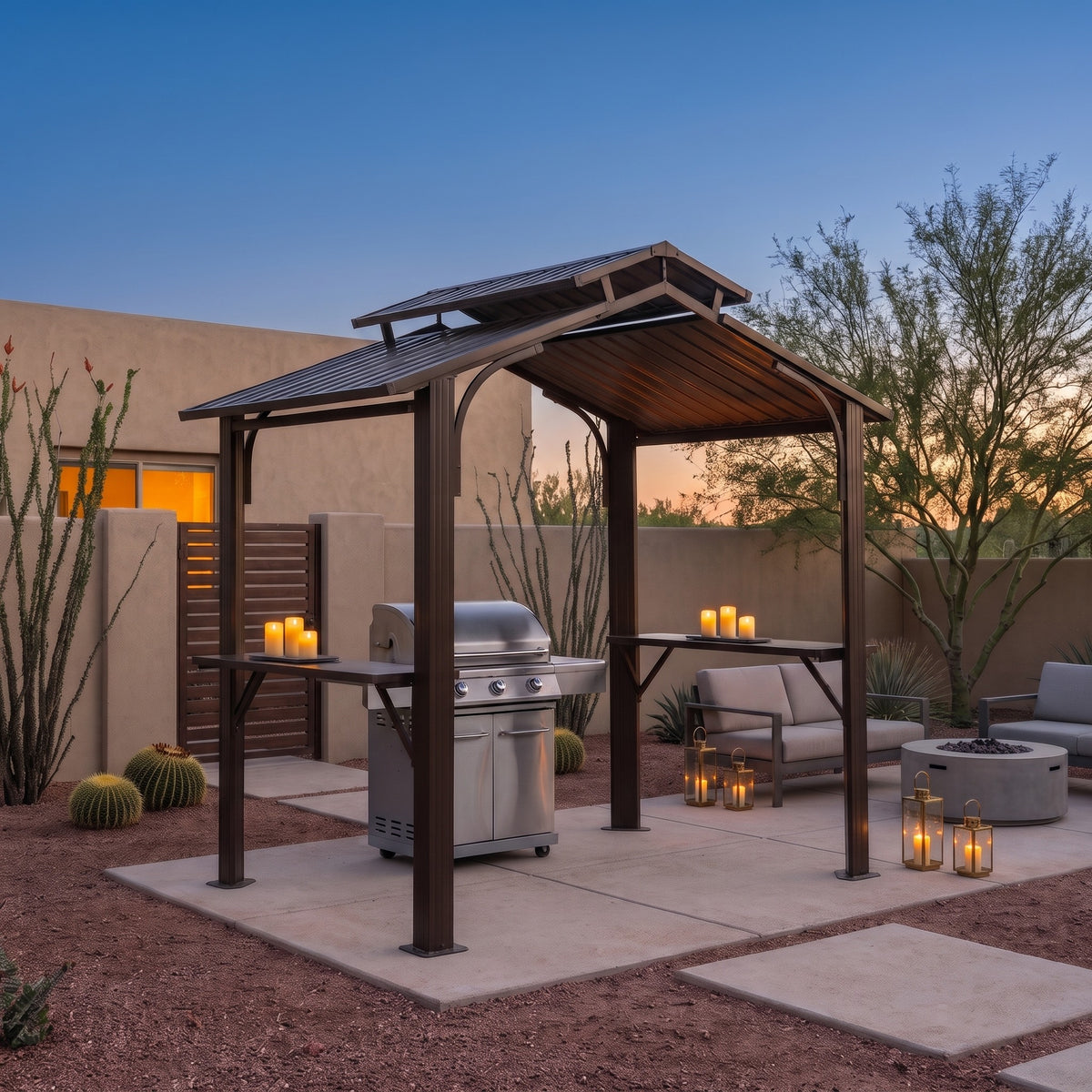 Brown metal double roof grill gazebo with side shelves over a steel grill on a desert patio at dusk, lit by candles