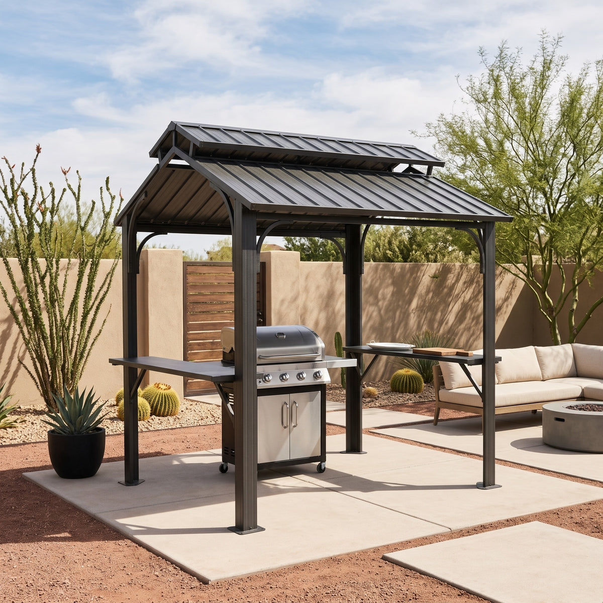 Gray metal double roof grill gazebo with side shelves over a gas grill on a desert concrete patio in afternoon sun