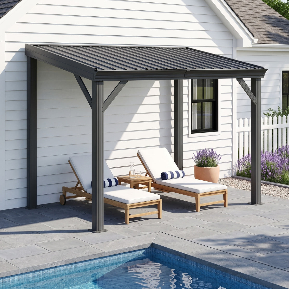 Gray metal lean-to hardtop gazebo against a white house shading two lounge chairs beside a pool
