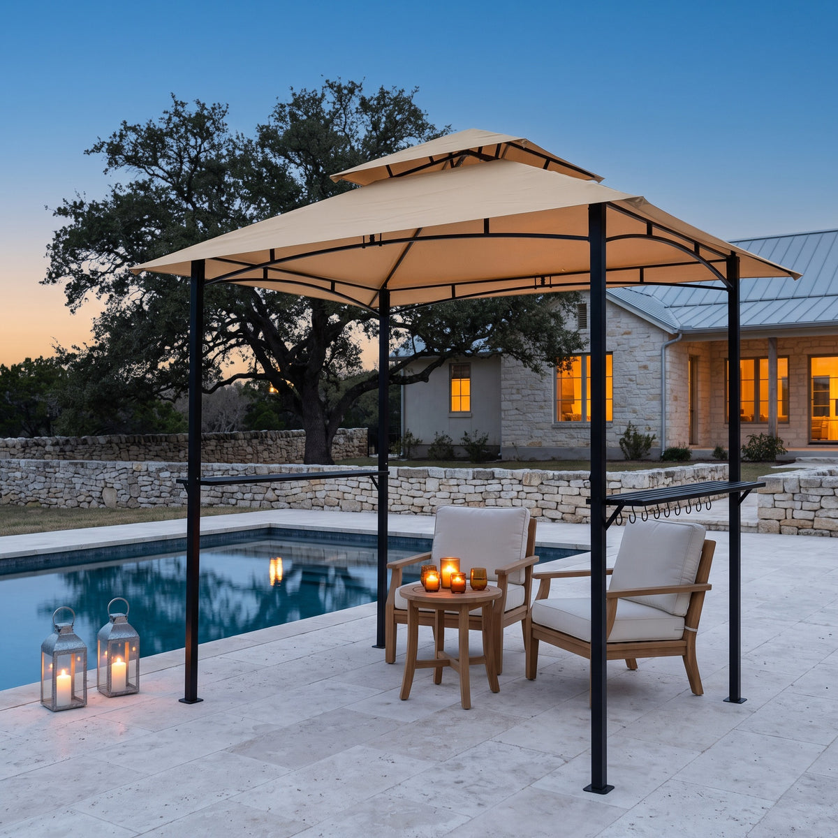 Khaki double roof metal grill gazebo with side shelves over two lounge chairs by a pool at dusk with candle lanterns