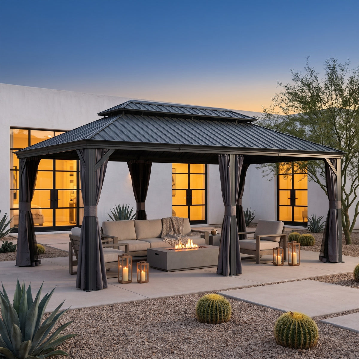 Gray aluminum double roof hardtop gazebo with tied back curtains over patio seating and a fire table at dusk