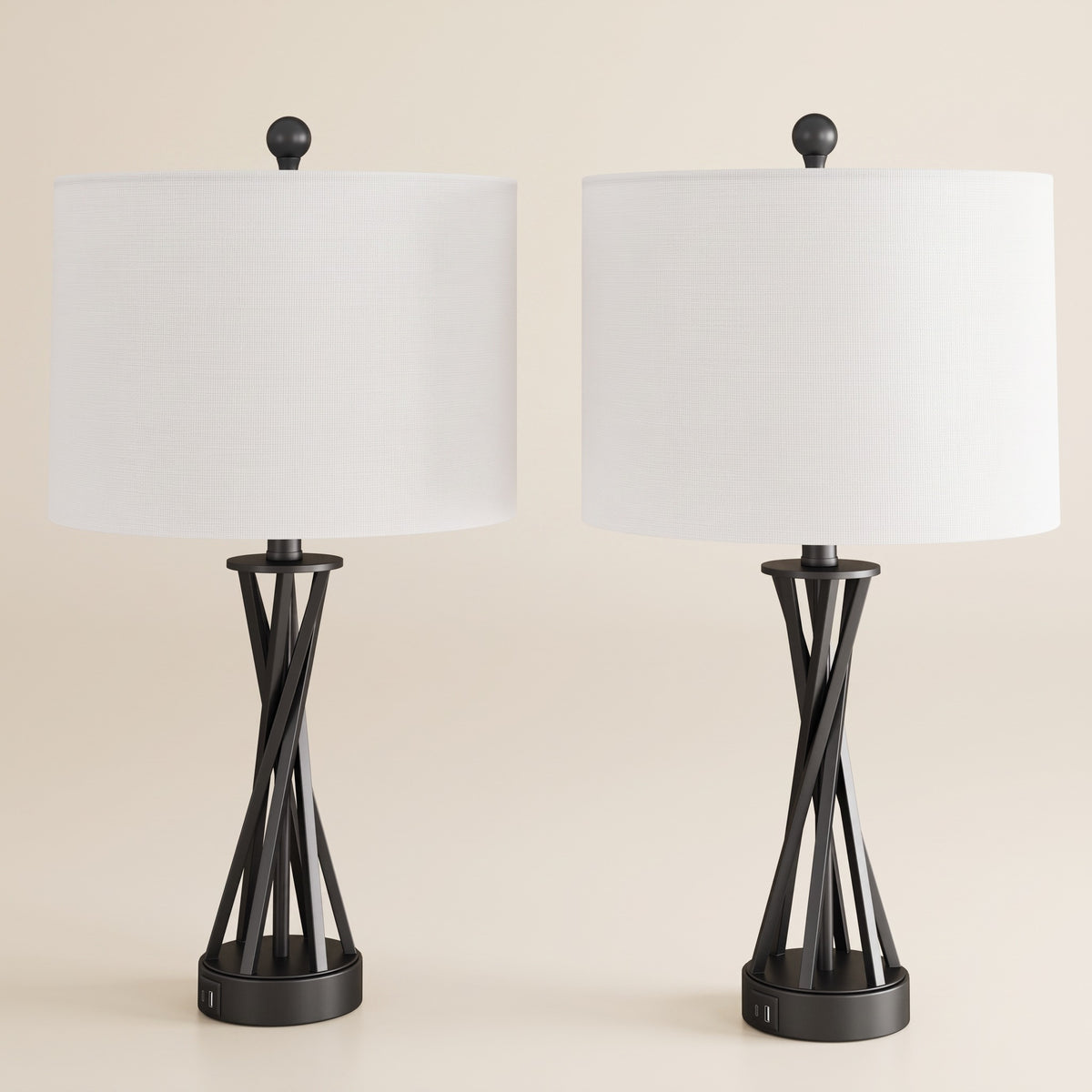 Set of two black metal table lamps with white linen-look drum shades and USB ports on an ivory backdrop