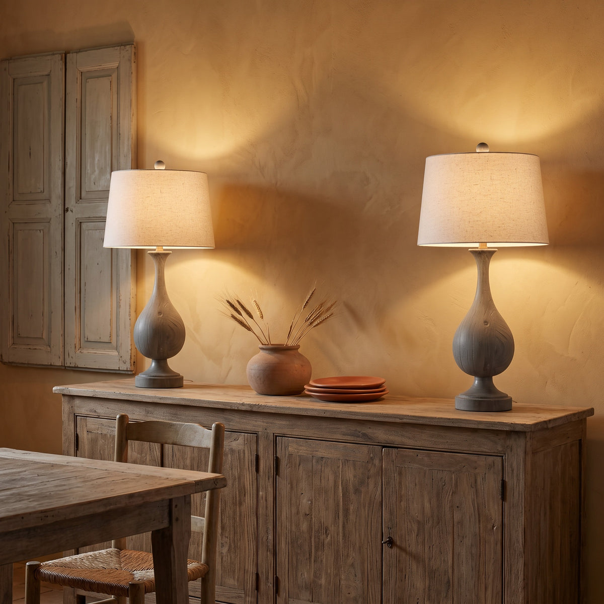Pair of grey wood-look table lamps with natural linen shades, lit on a rustic wood sideboard