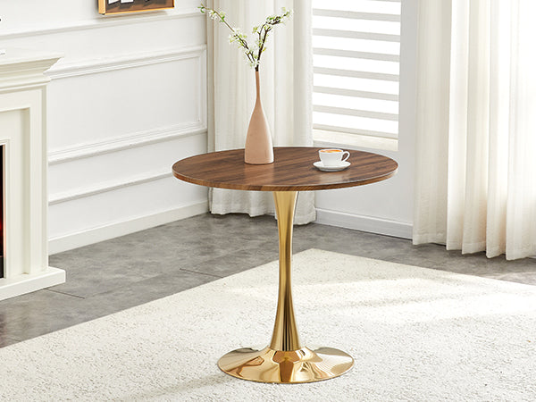 Walnut-top gold-base dining table with a vase and cup by a curtained window, three-quarter view