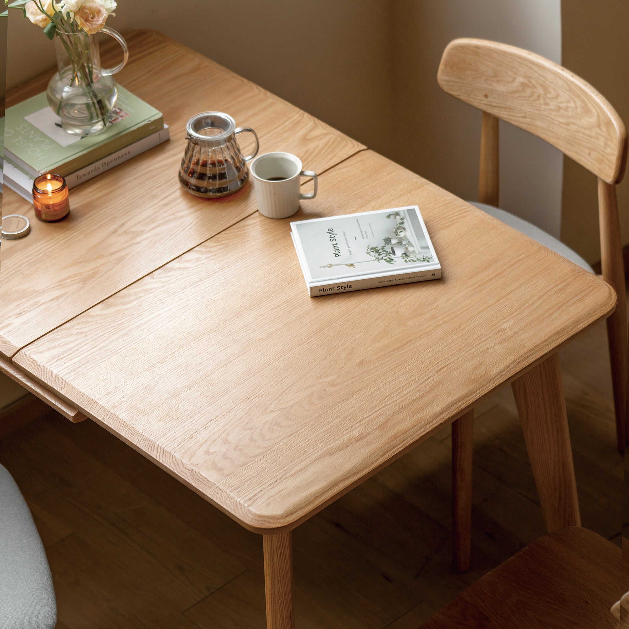 Overhead close-up of the natural oak tabletop with a coffee pot, mug and book