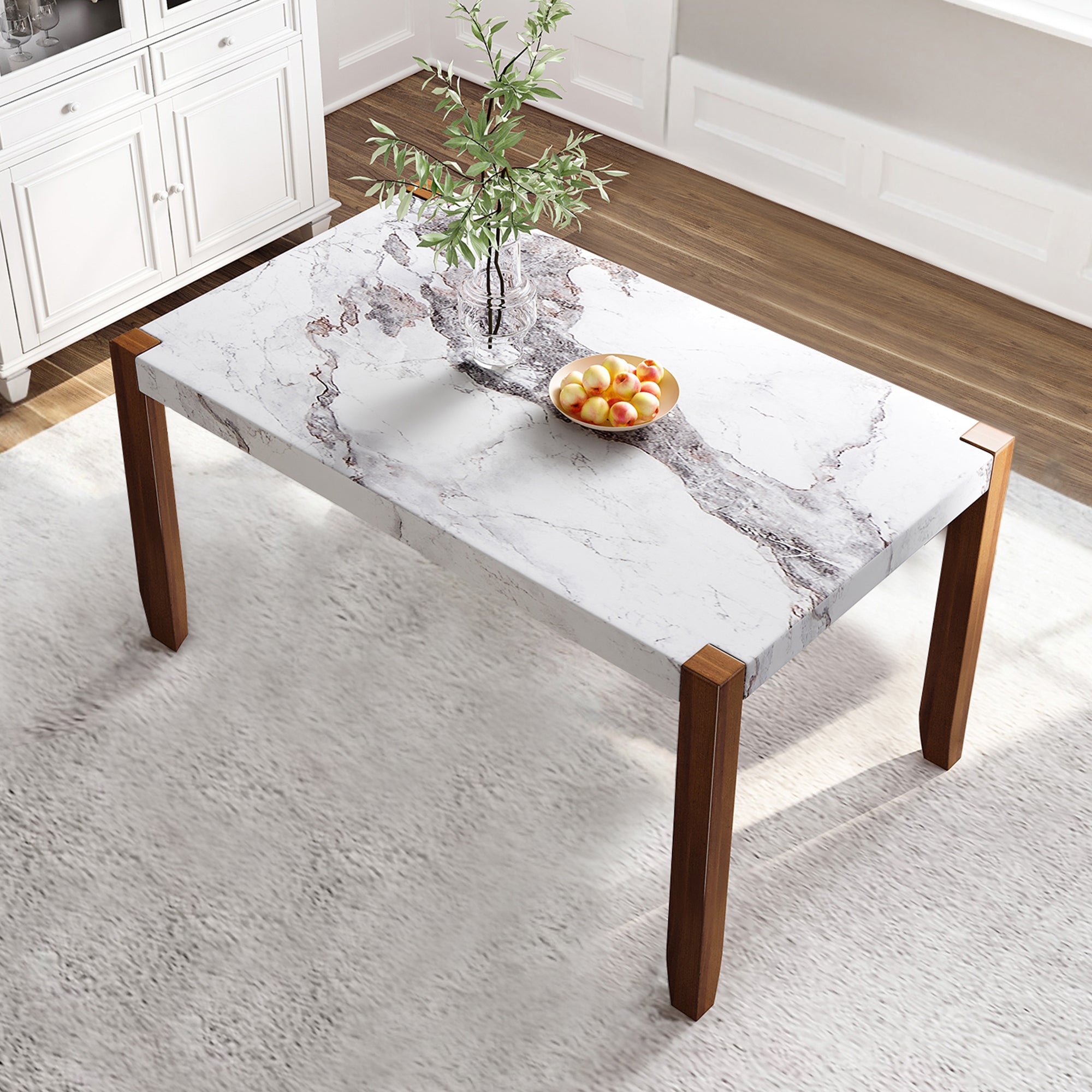 Overhead angled view of the faux marble dining table with brown legs in a sunlit dining room