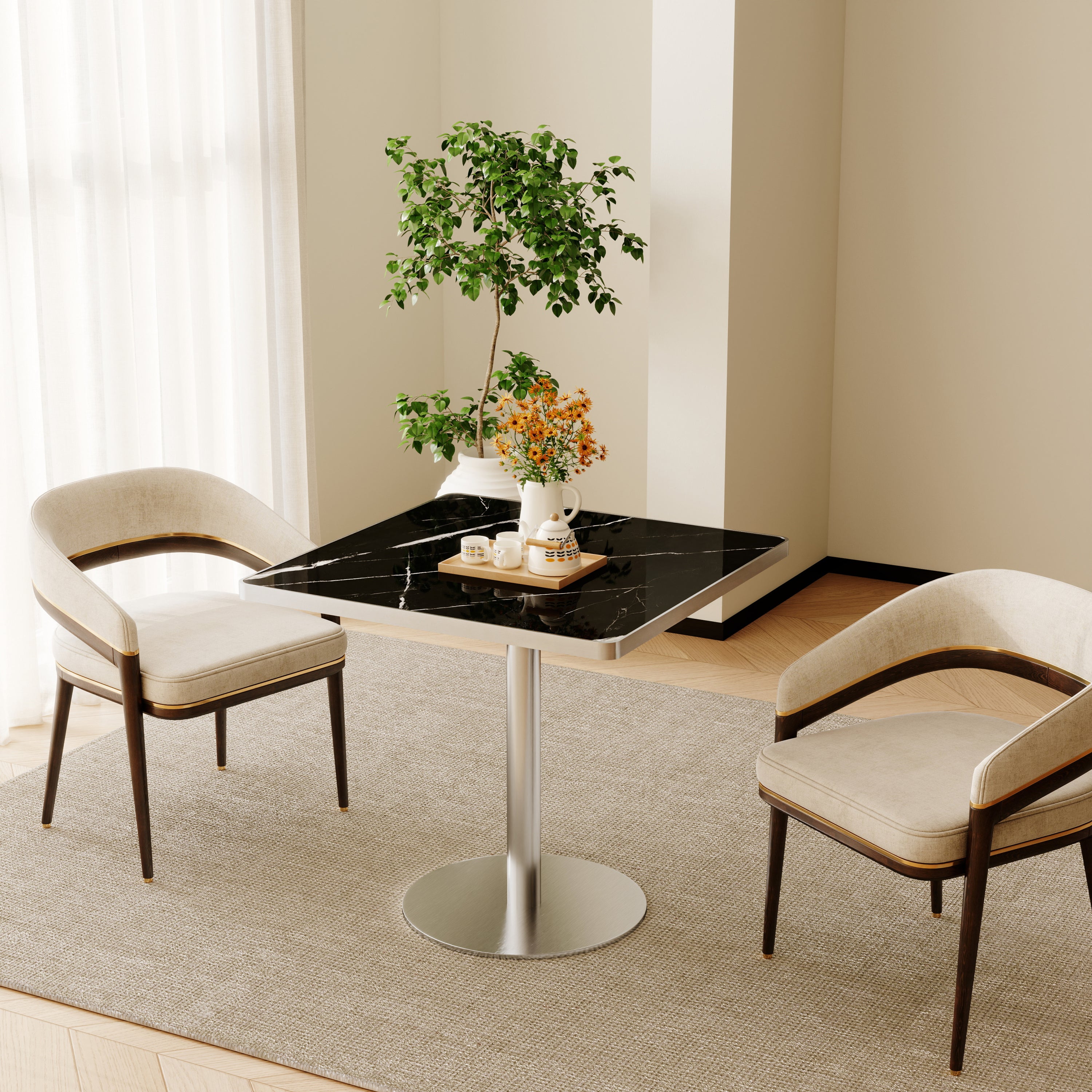 Black sintered stone square table styled in bright room with two cream chairs and plant