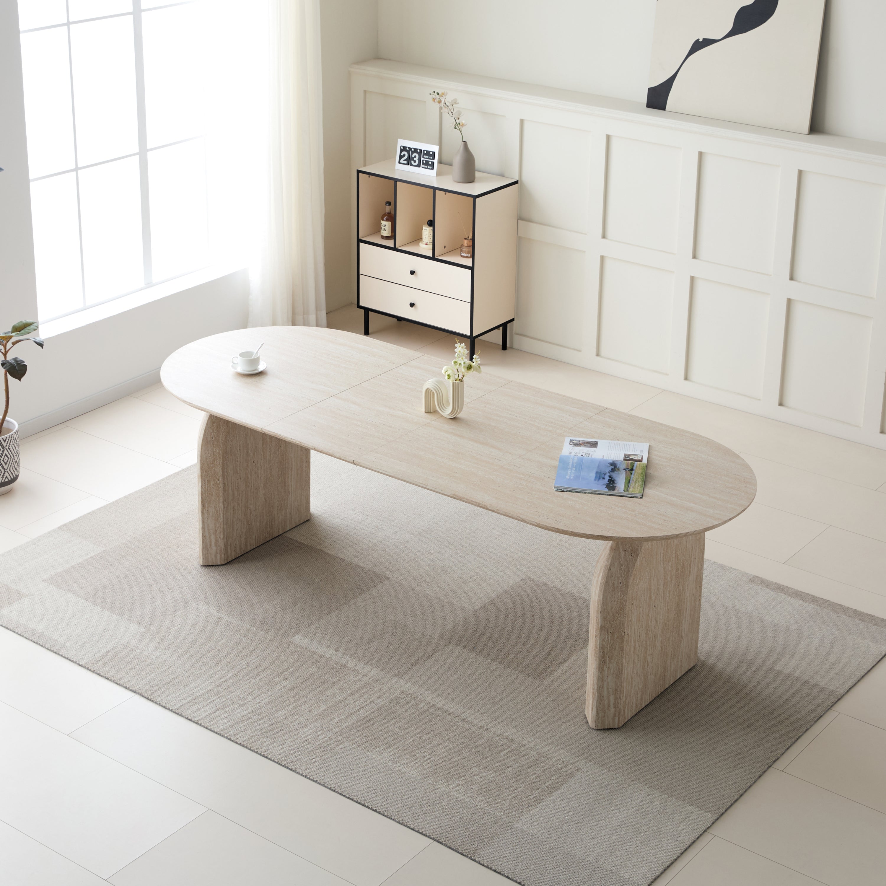 Overhead view of off-white oval extendable dining table with dual-pillar base in a bright living room