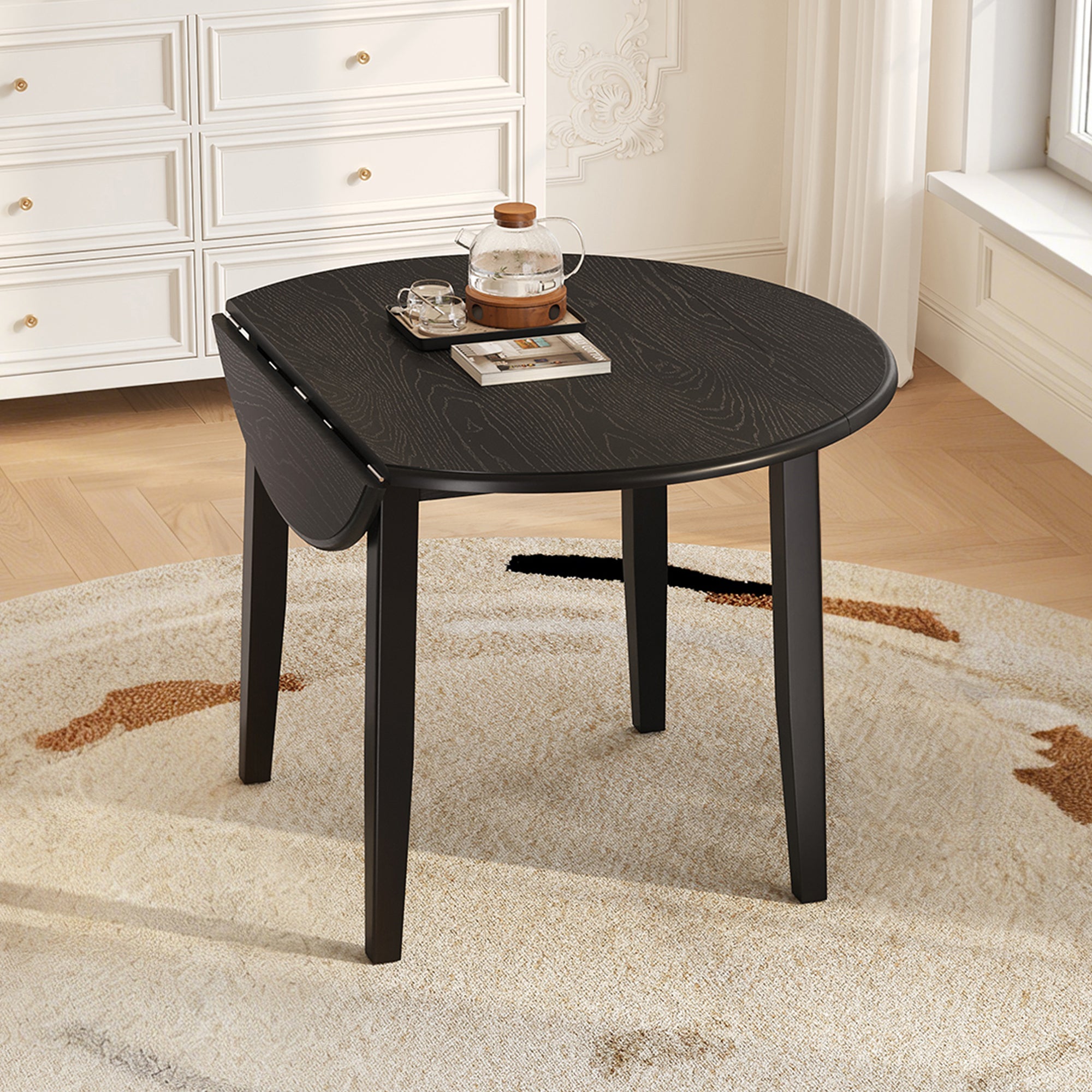 Styled room with the black folding round table, one drop leaf folded down and a teapot on top