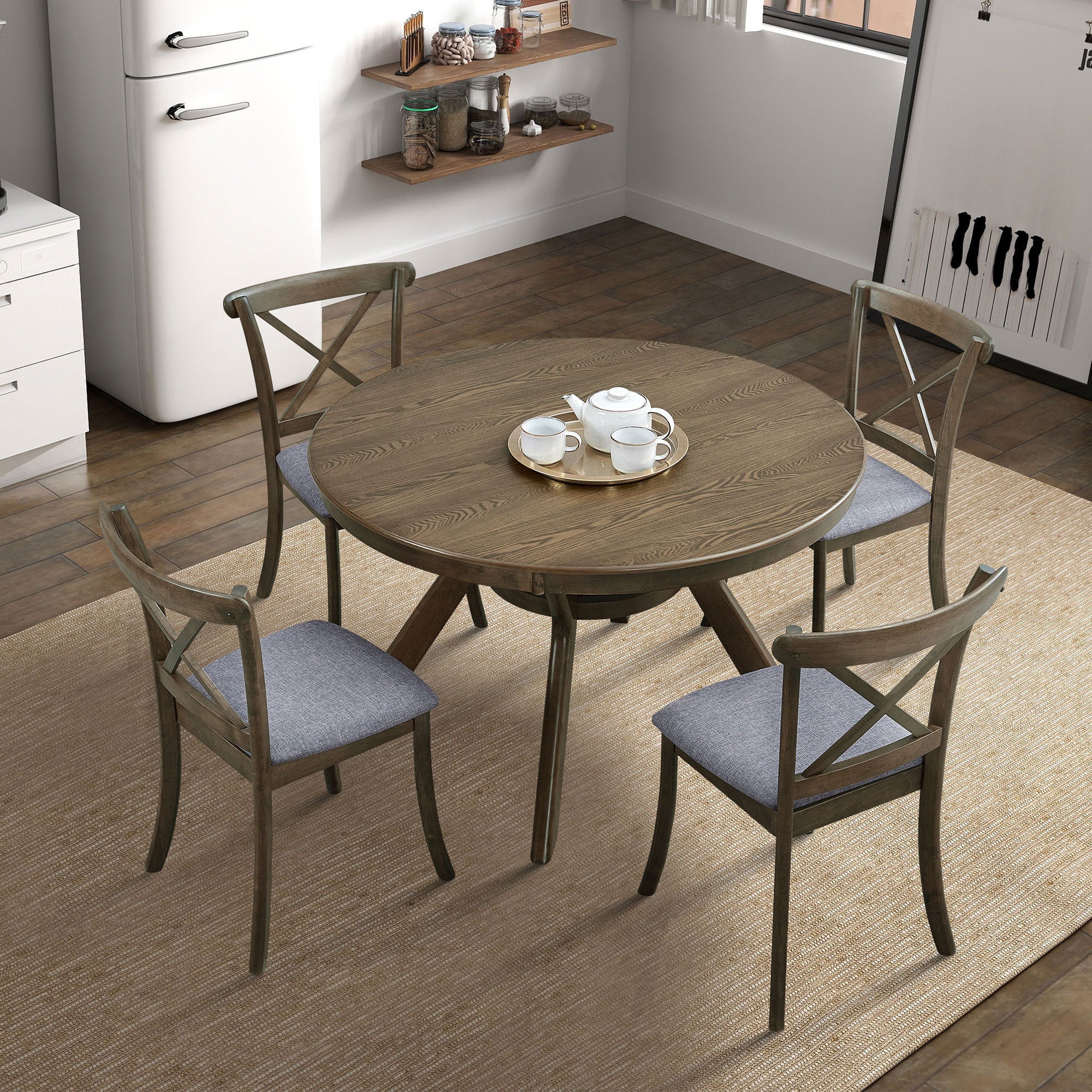 Overhead angled view of round oak dining table and four chairs with a gold tea tray in a kitchen