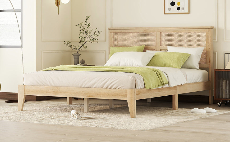 Angled view of the natural wood queen bed frame and rattan headboard with layered neutral bedding