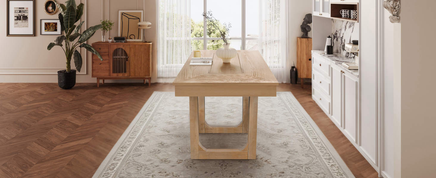 Wide end-on view of the oak farmhouse dining table styled in a bright dining room