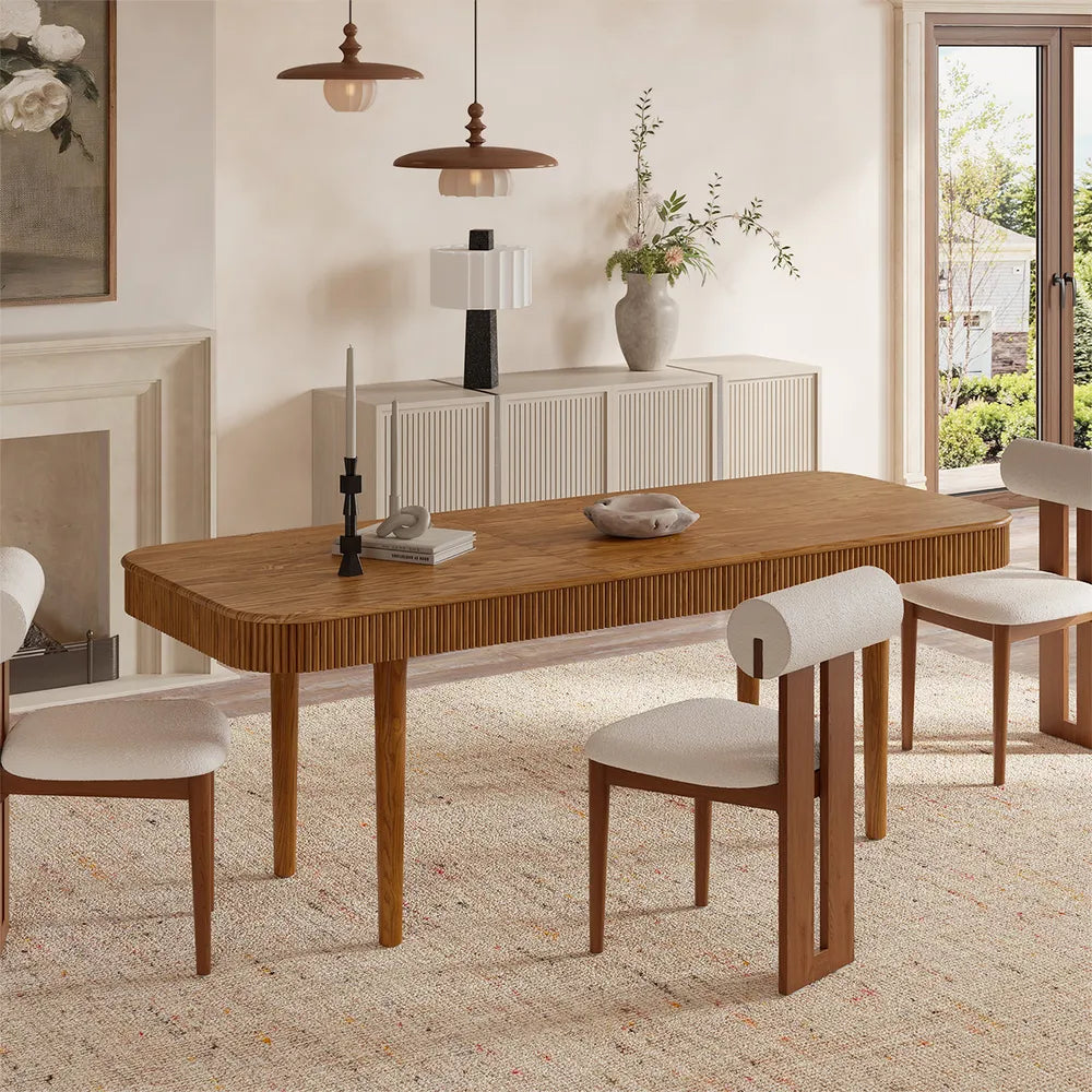 Lifestyle image of ash wood extendable dining table with fluted detailing, shown fully styled in a warm, mid-century inspired dining space.