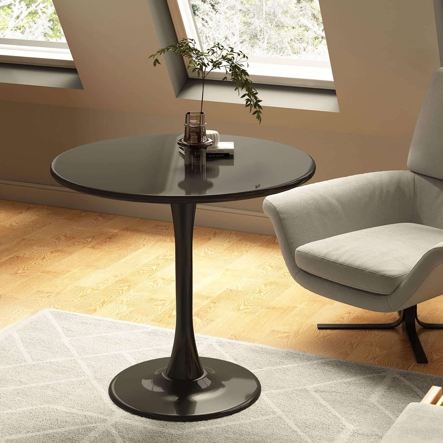 Round black tulip table with a vase in a bright attic living room