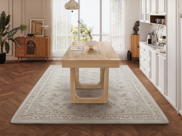 Angled end view of the oak farmhouse dining table on a patterned rug in a styled room