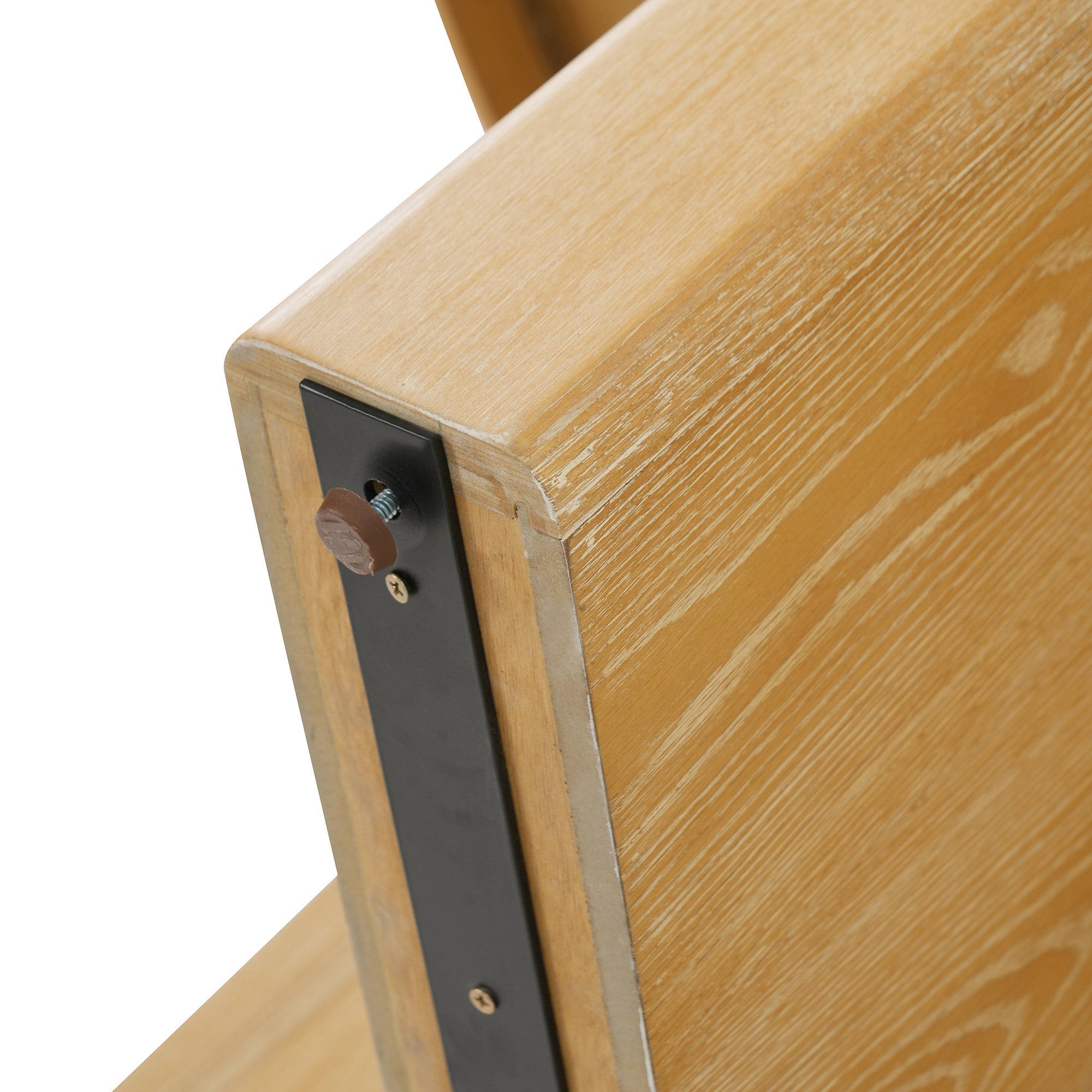 Close-up of a corner underside showing the black bracket and brown bolt cap