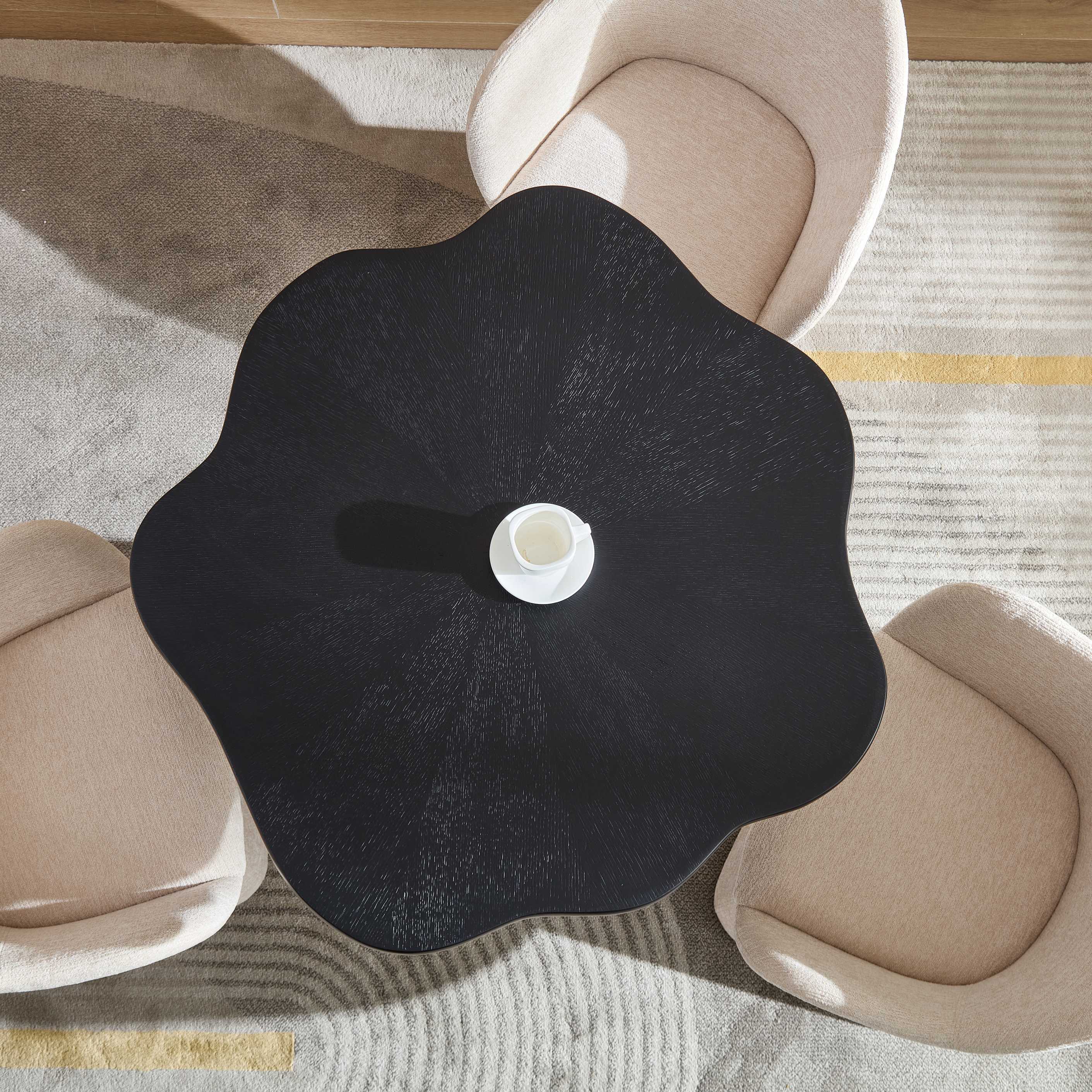 Overhead view of the flower-shaped black petal dining table with a coffee cup and chairs