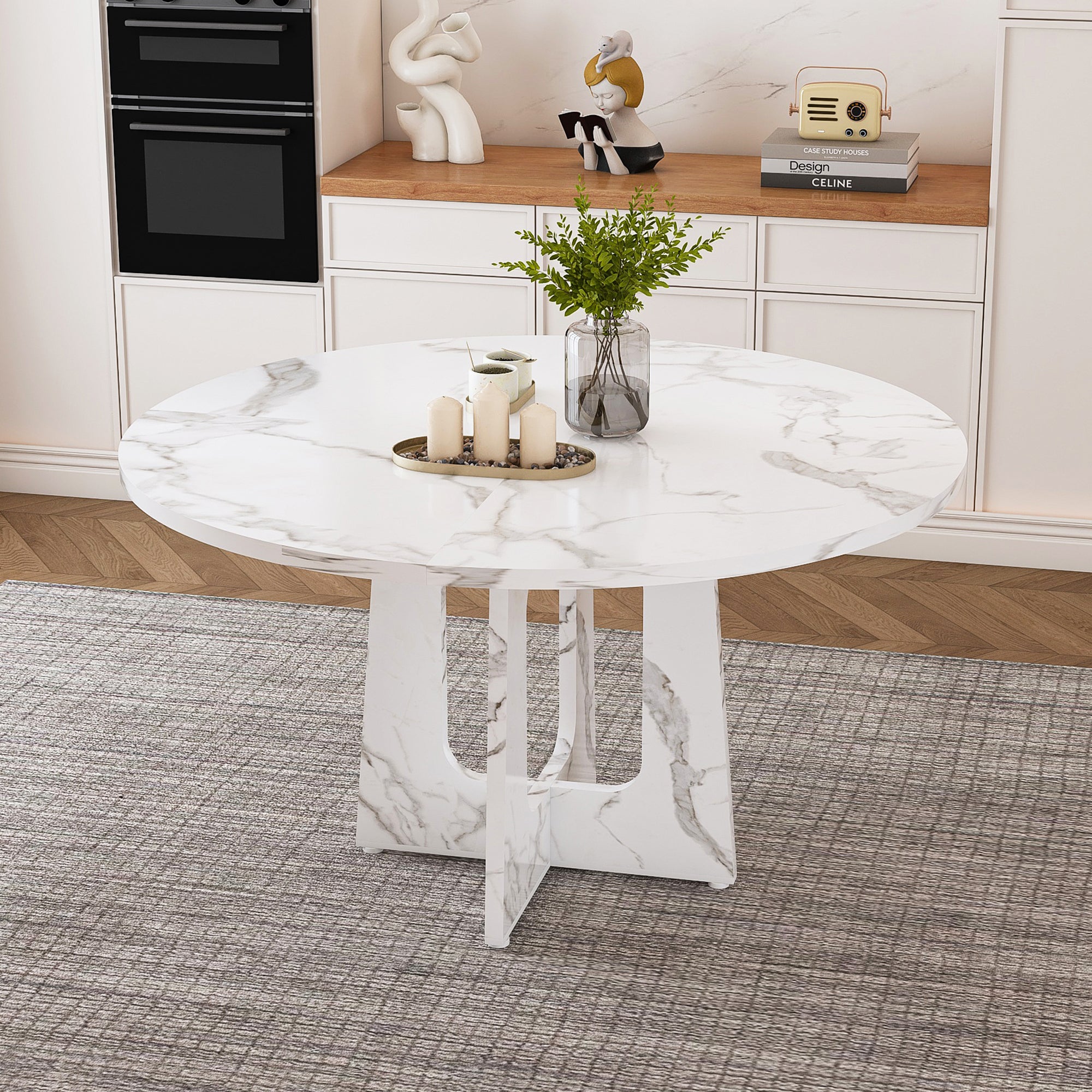 White faux marble round table with candles and a plant styled in a kitchen, three-quarter view