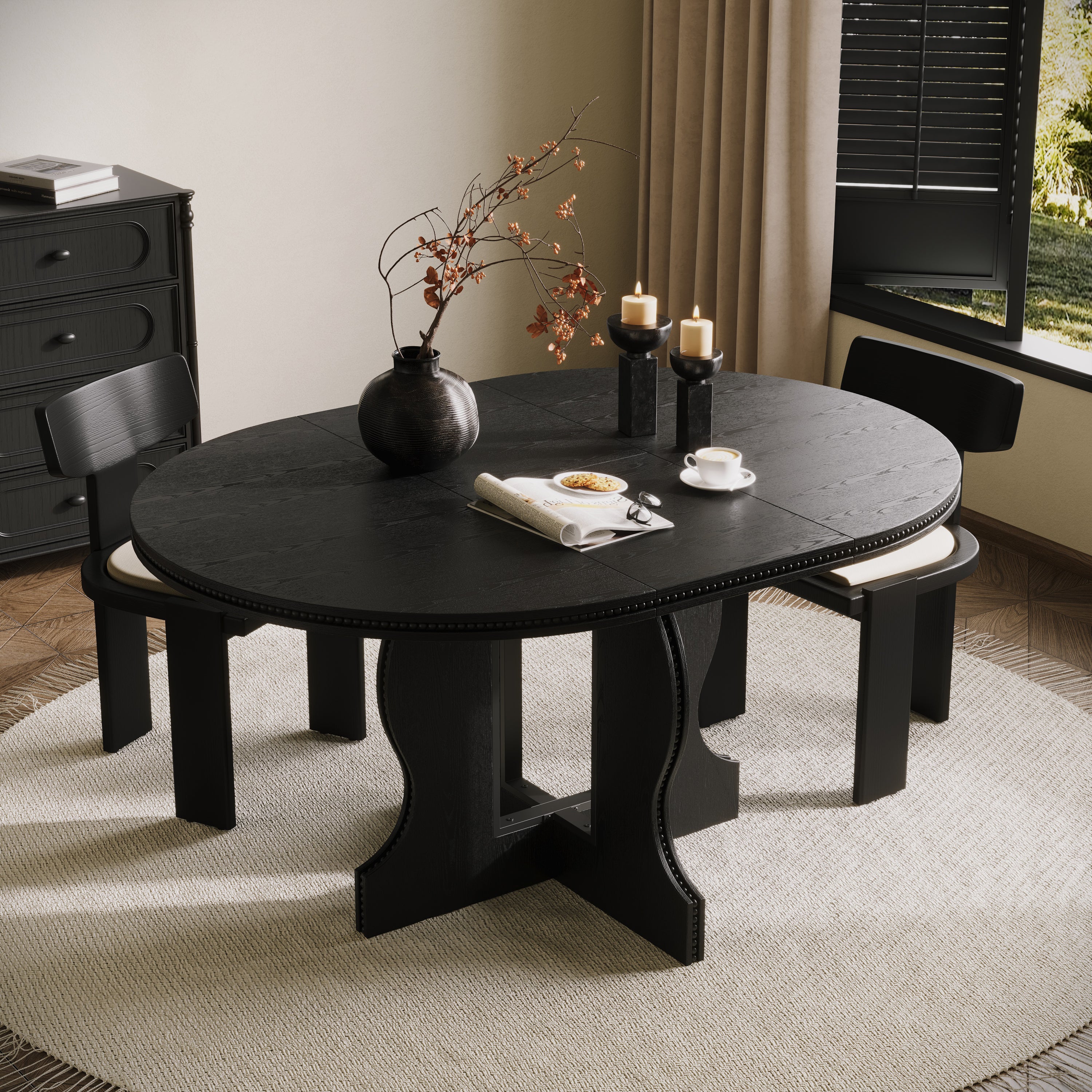 Black round pedestal dining table with two chairs, overhead angle in a styled dining room