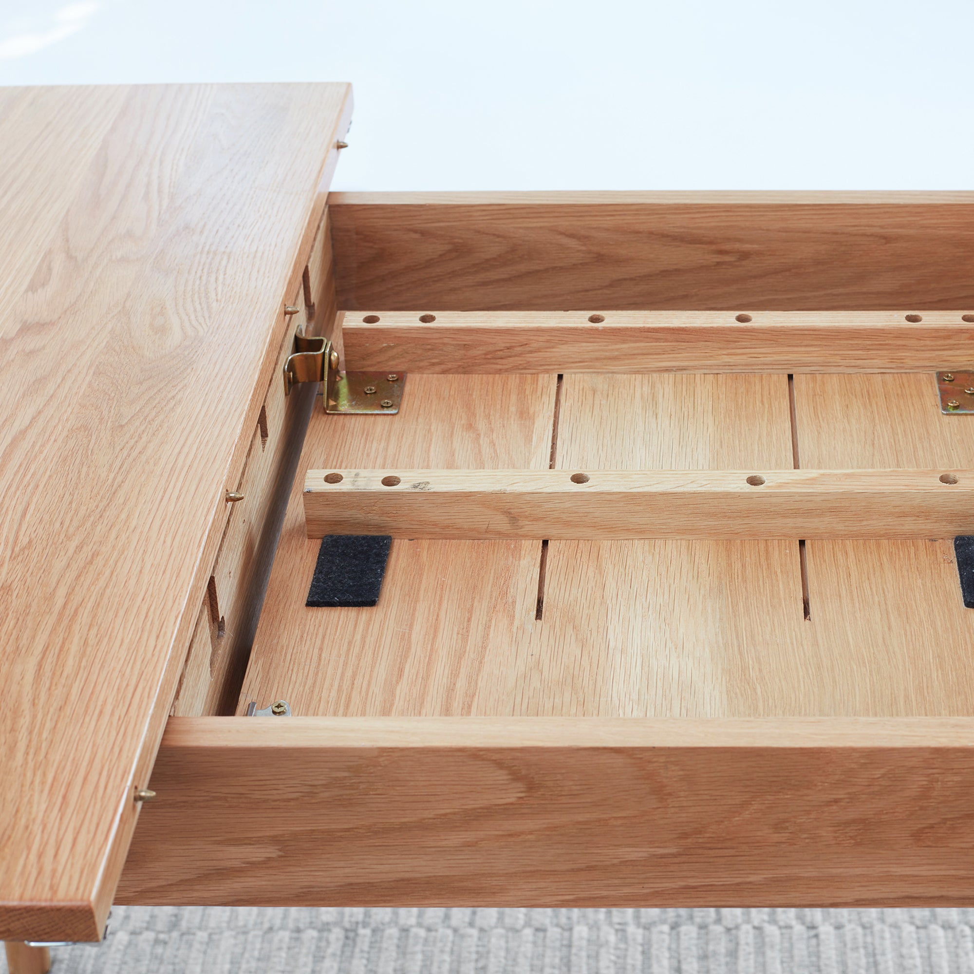 Close-up of the opened extension showing brass hinge plate, dowel pins and slide rails