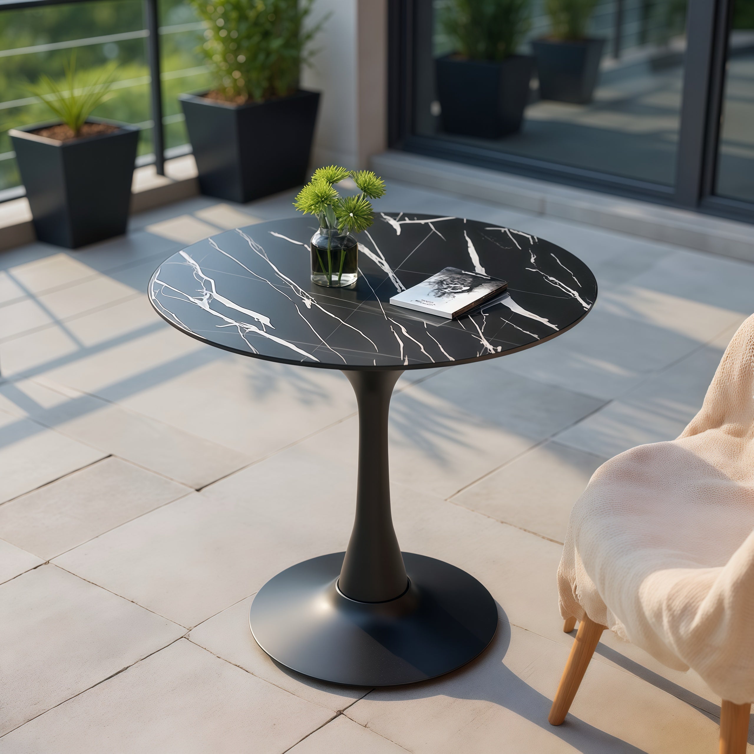 Overhead angle of black marble round bistro table on a sunlit balcony patio