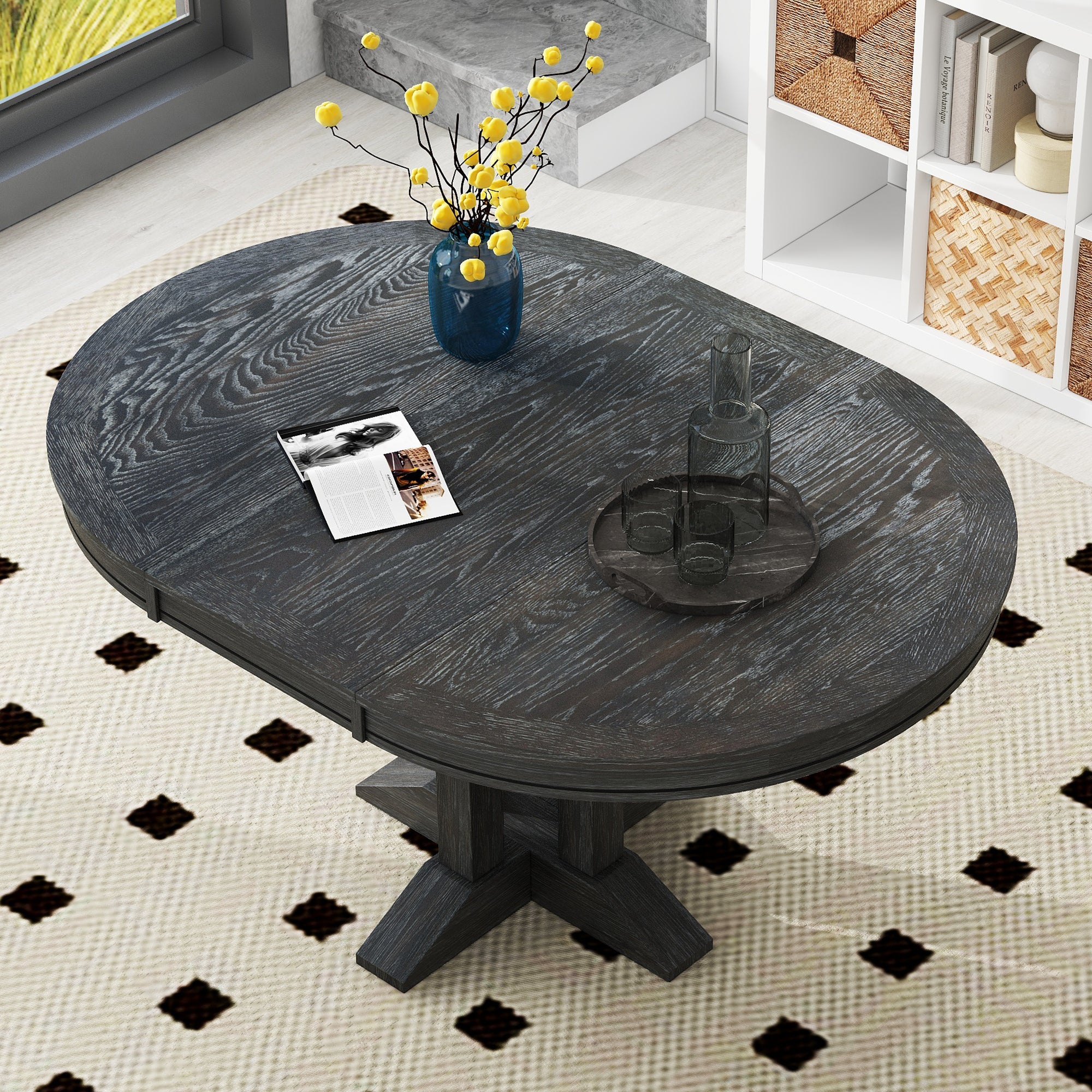 Overhead angled view of the black oval-extended tabletop in a styled room