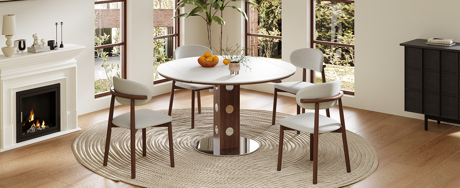 White round folding dining table with four cream chairs beside a fireplace