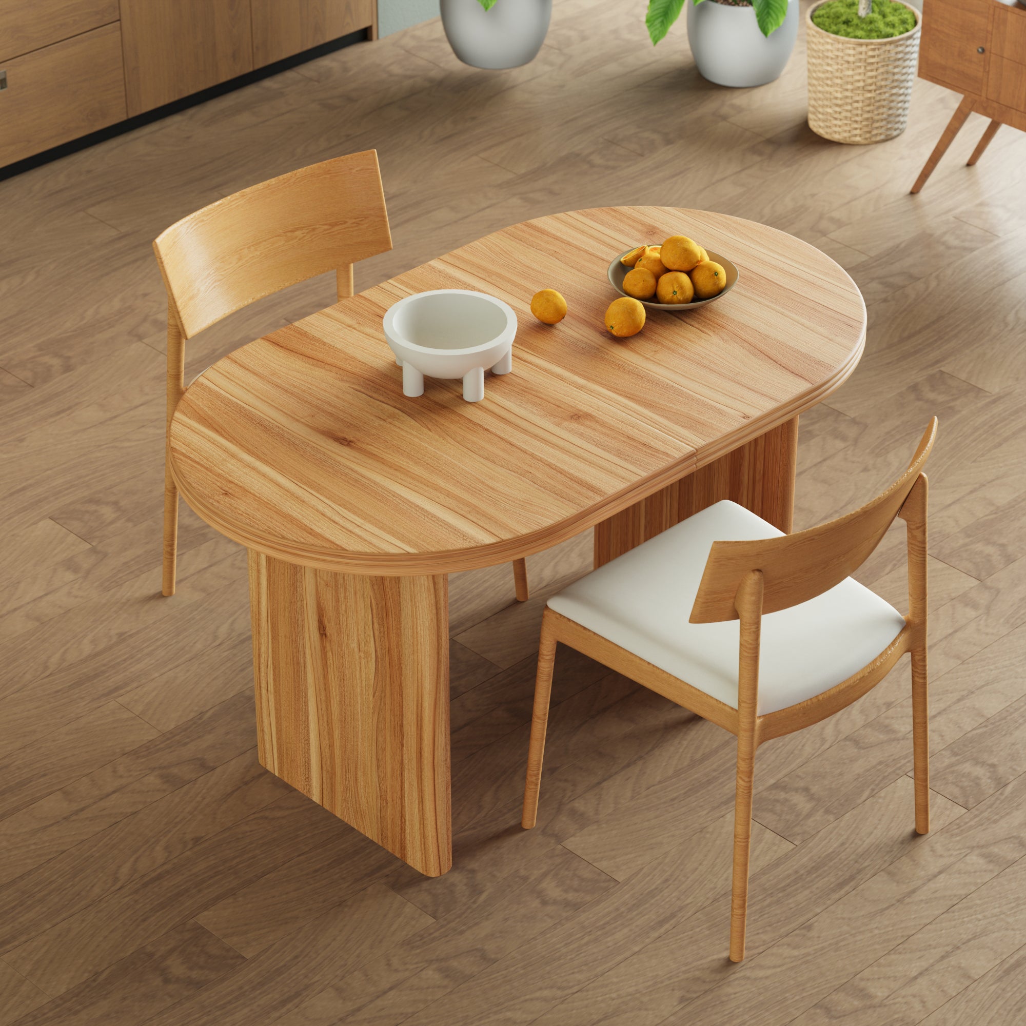 Overhead angled view of the closed oval table with a footed bowl and oranges