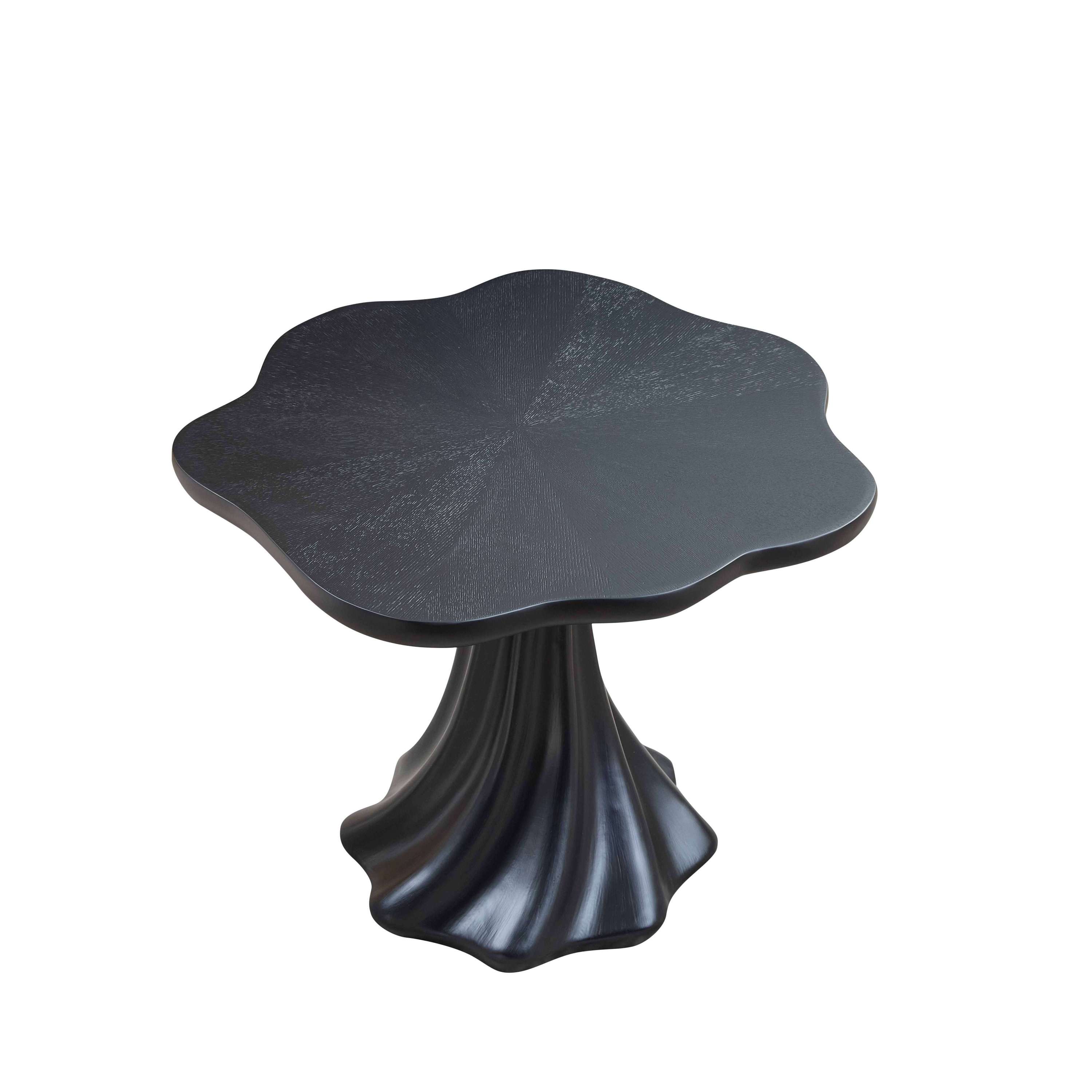 Black petal-shaped dining table on a plain white background, overhead three-quarter view