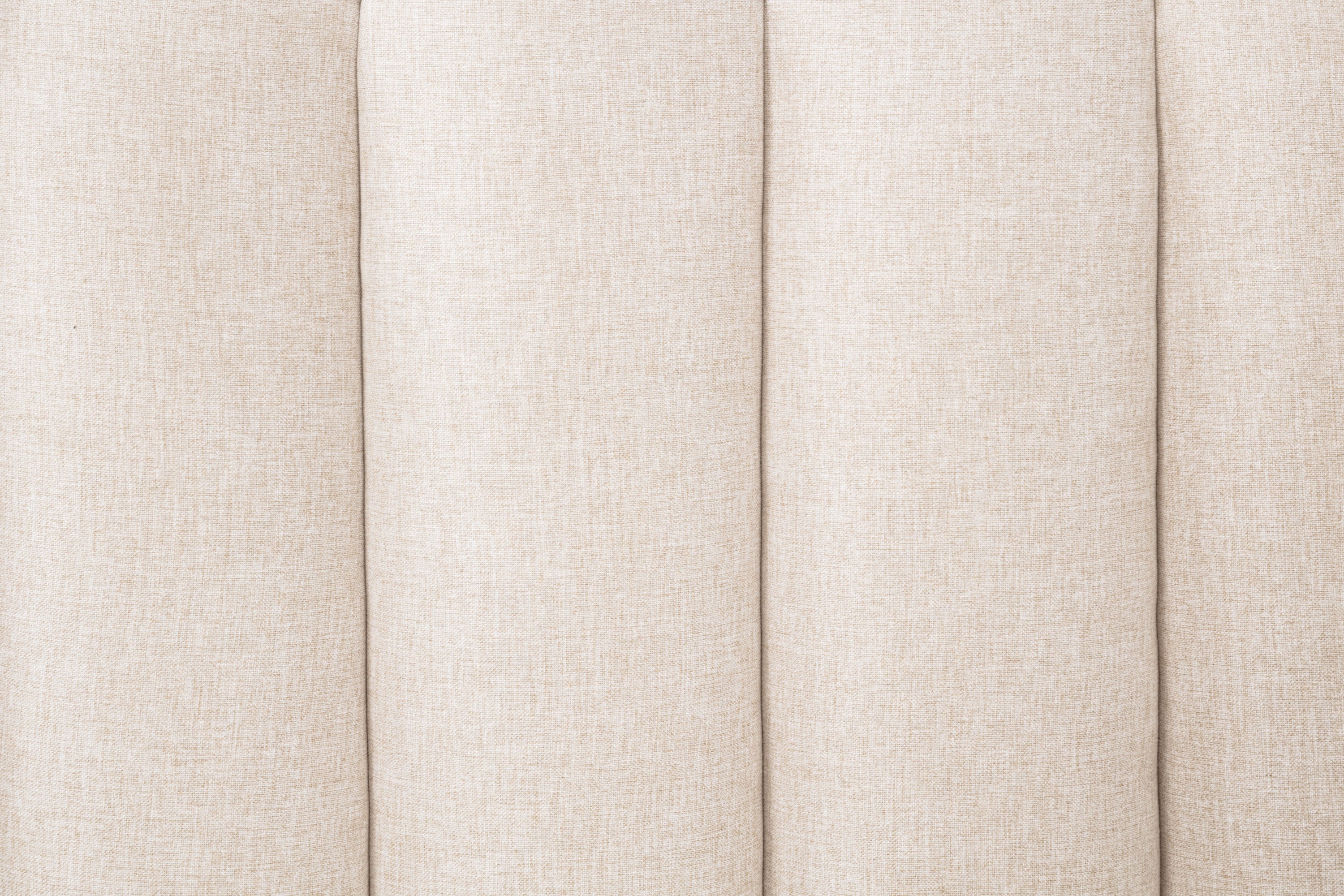 Extreme close-up of the woven wheat headboard fabric and its piano-key channel seams