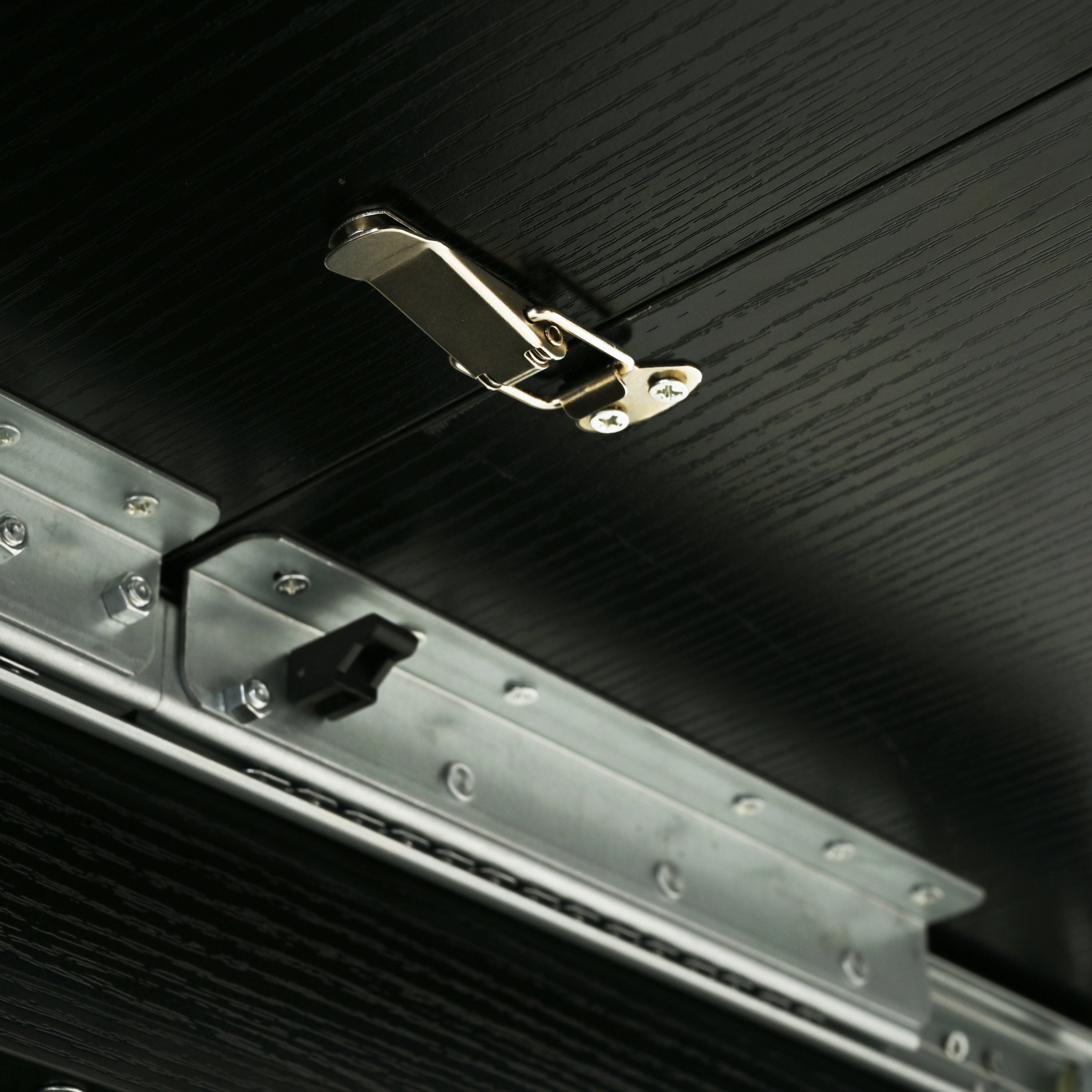 Close-up of the underside slide rail, toggle latch and black stopper